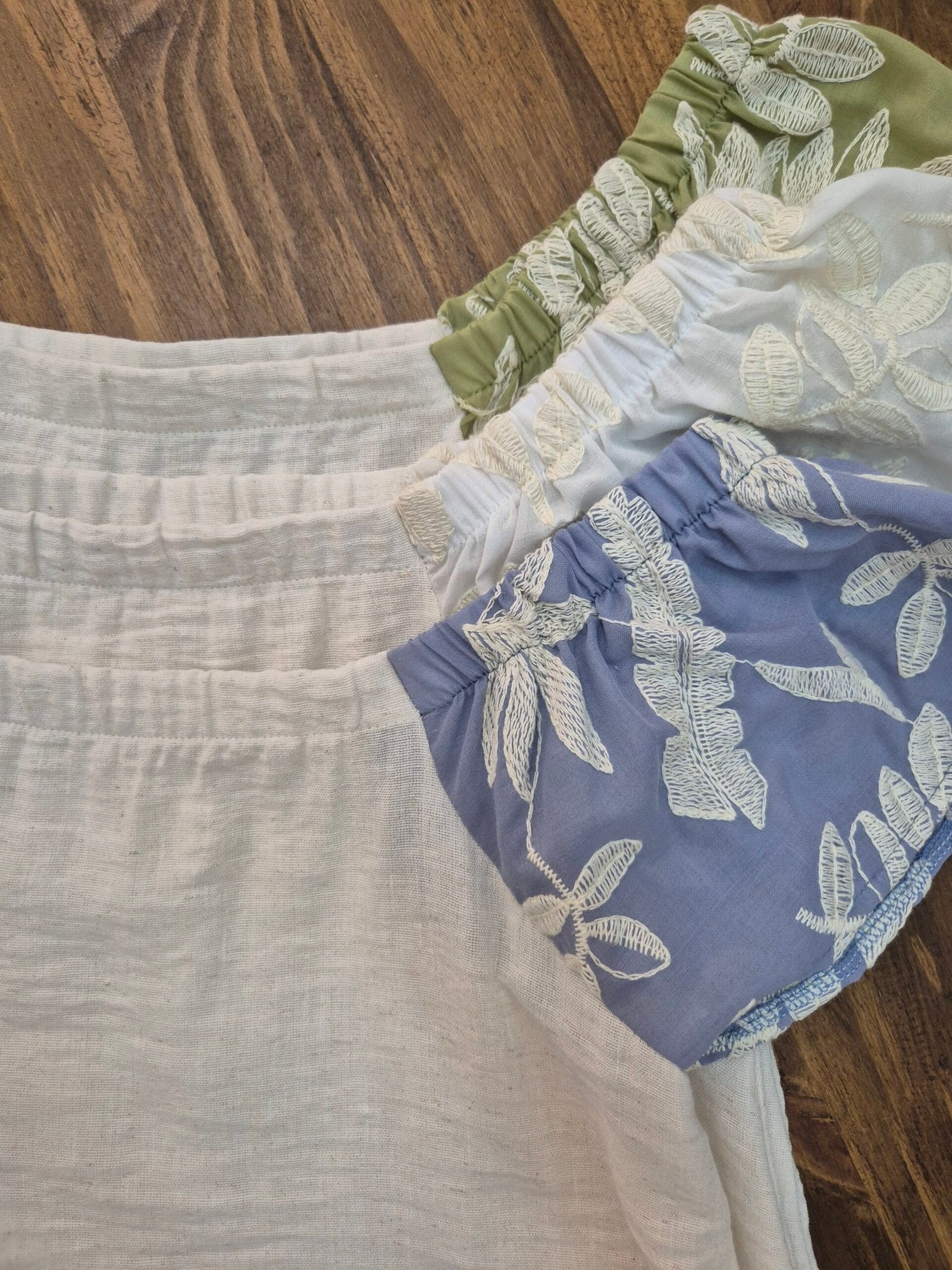 Blusa con frente liso blanco y mangas con volados en estampado de hojas
