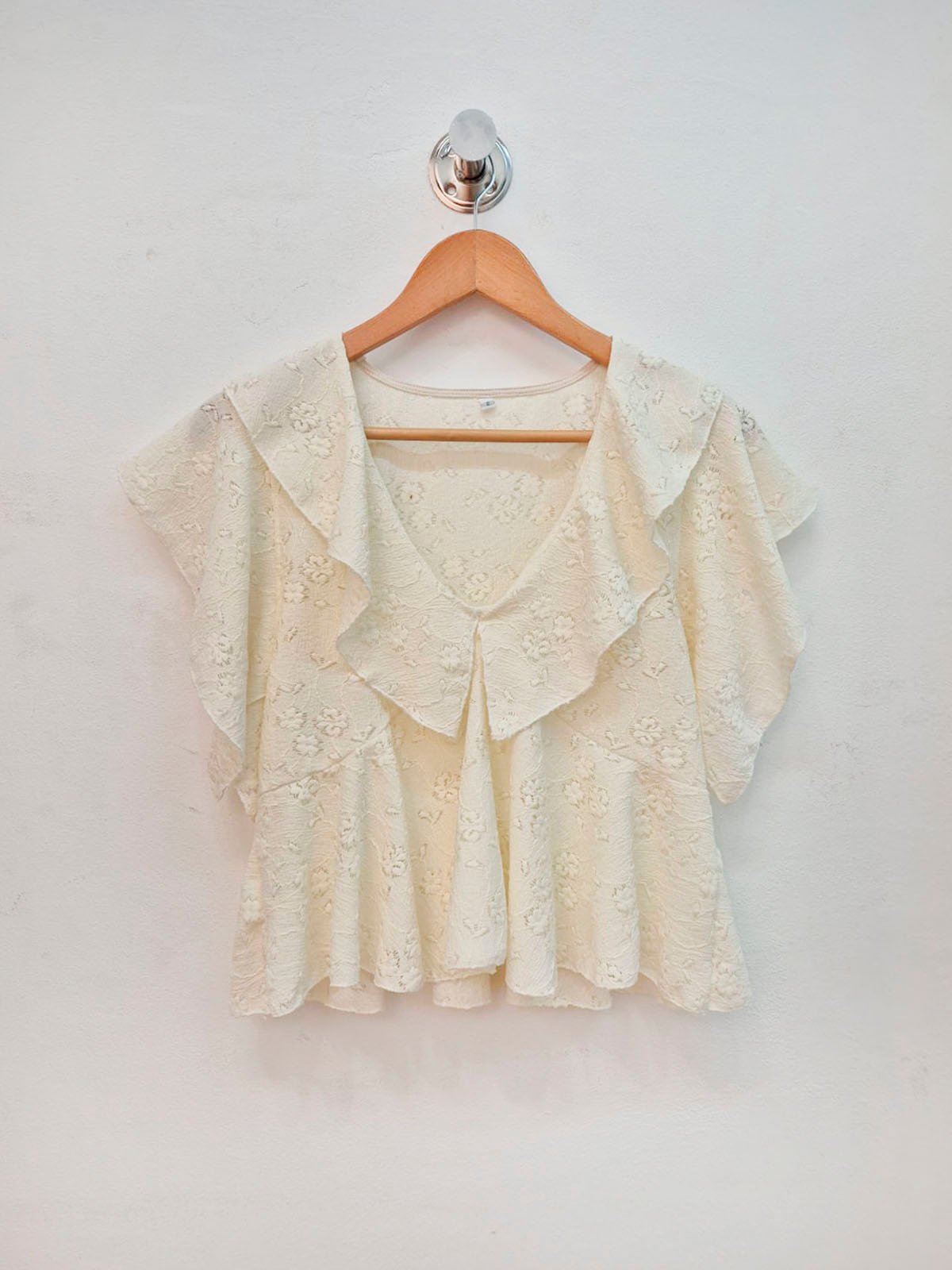 Blusa crema de encaje con volados y escote en V