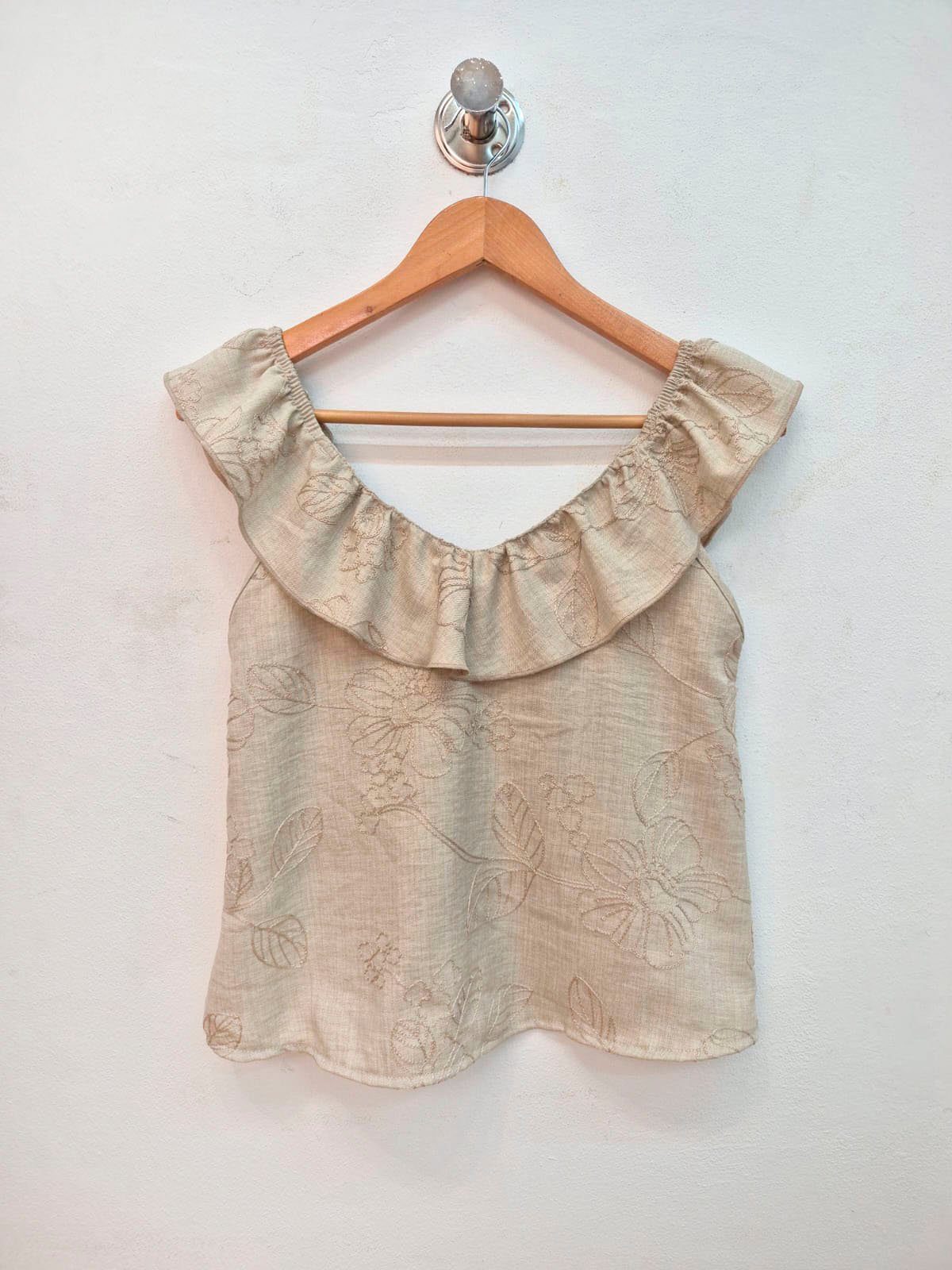 Blusa beige con volado floral y escote redondo sin mangas