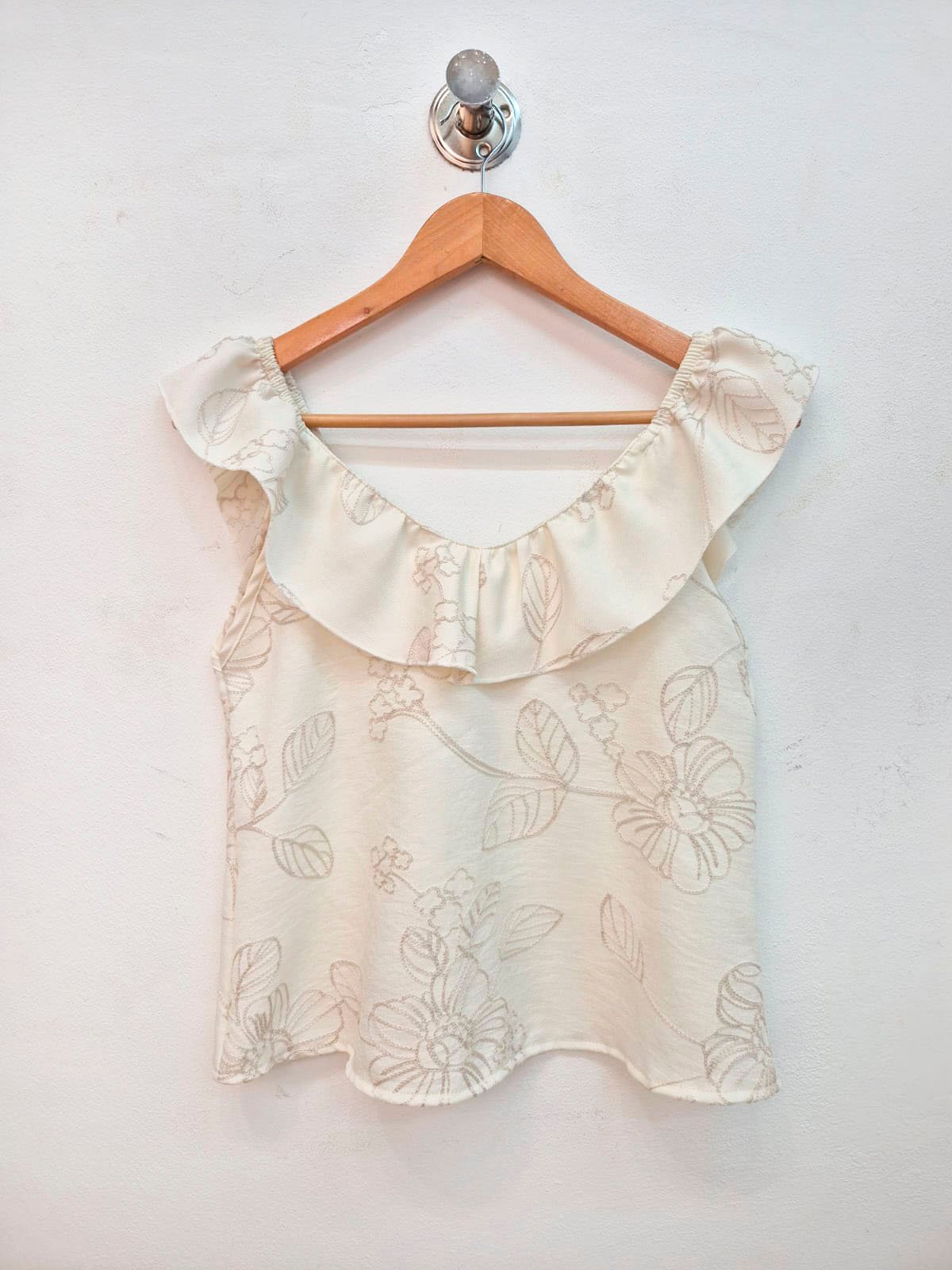 Blusa blanca con estampado floral beige y volante en escote