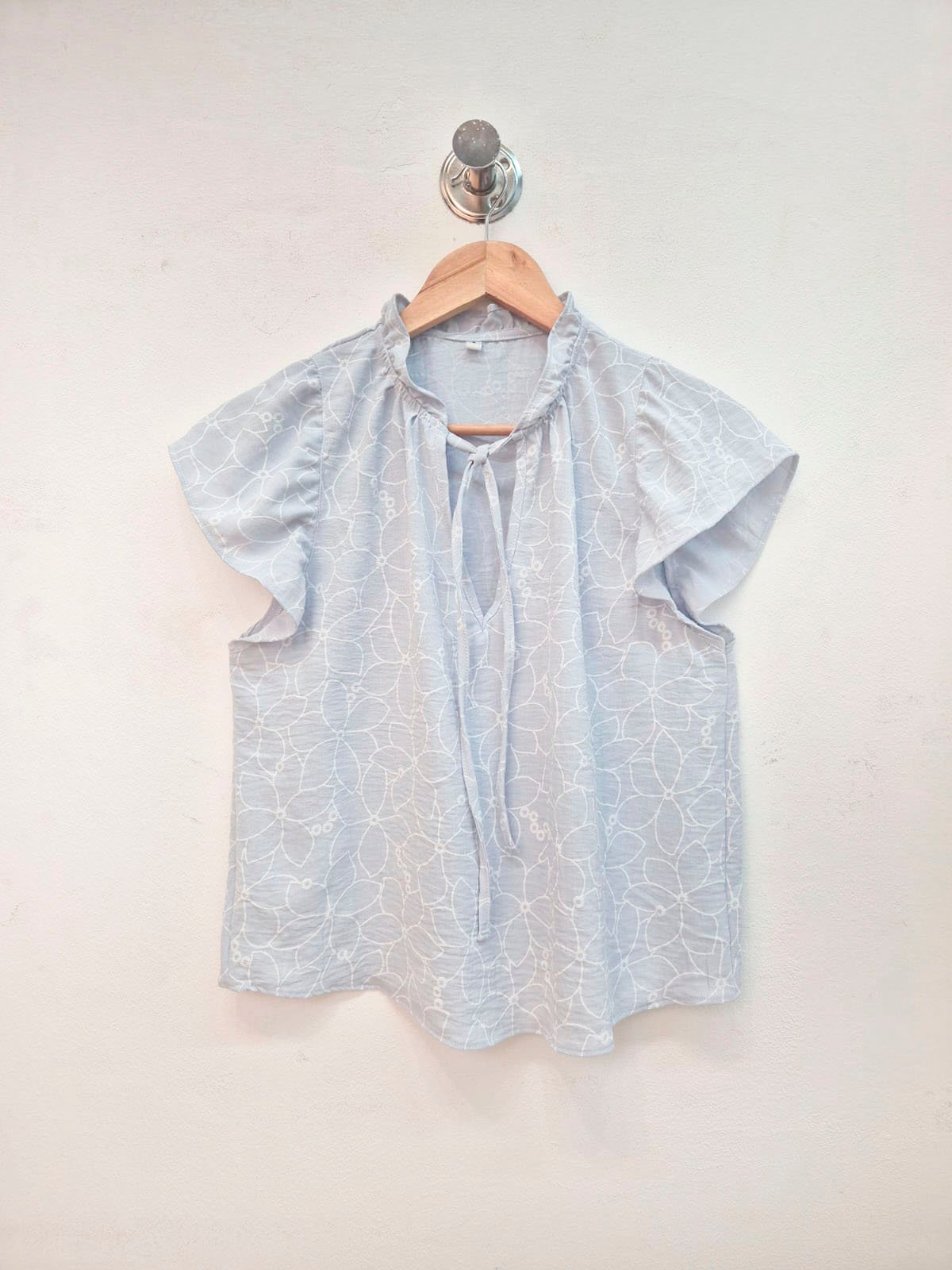 Blusa celeste con estampado de flores y mangas volantes cortas