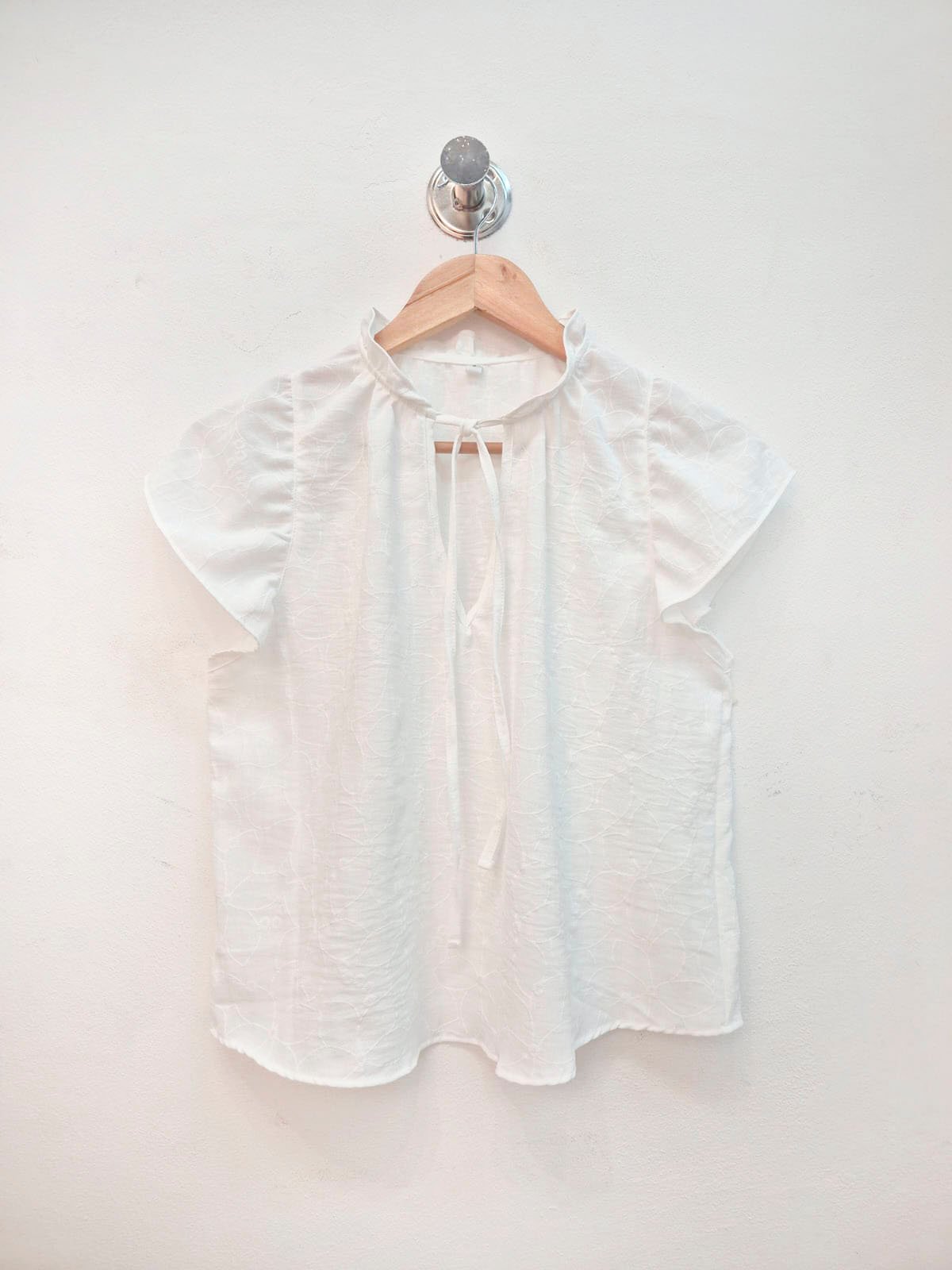 Blusa blanca de lino con mangas voladas y cierre frontal