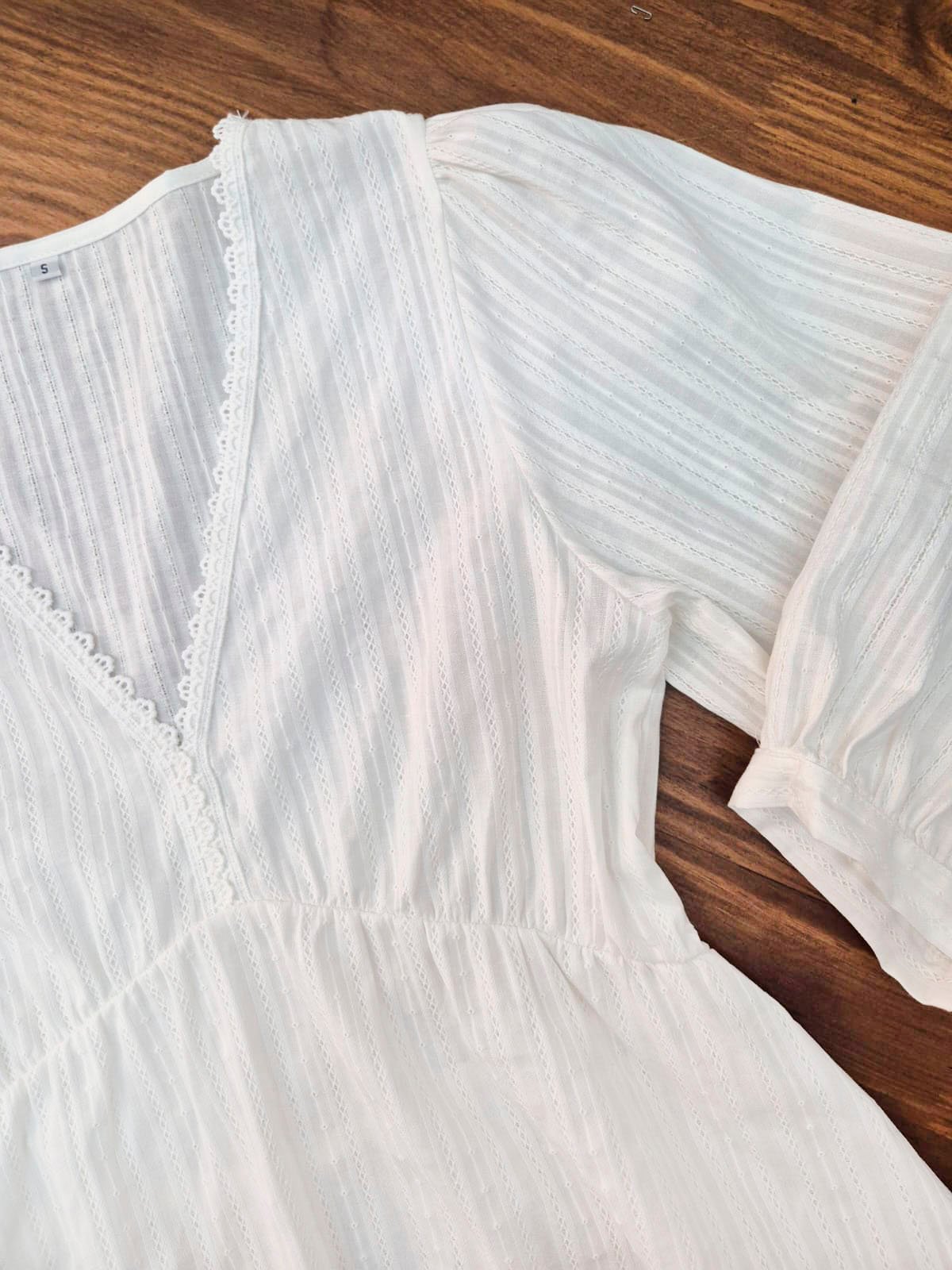 Blusa blanca de algodón con escote en V y manga larga acanalada