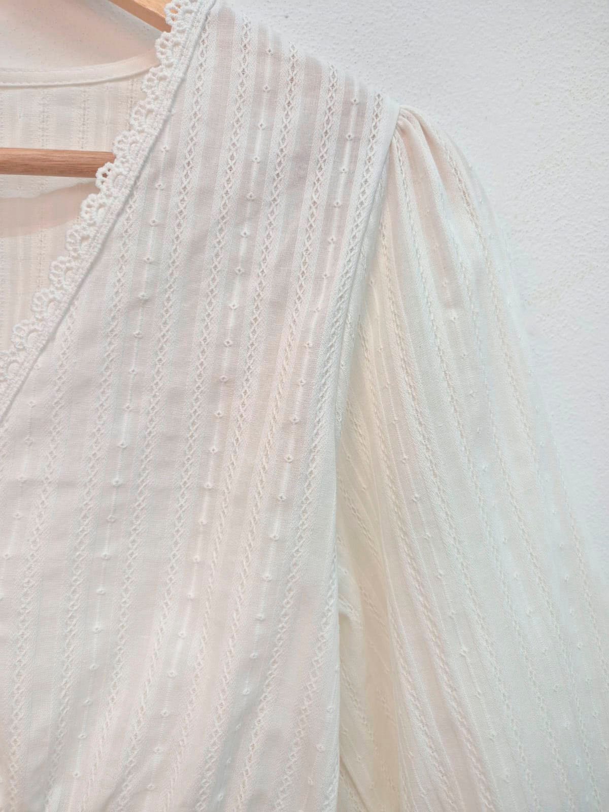 Blusa blanca con encaje y detalles de perlas verticales