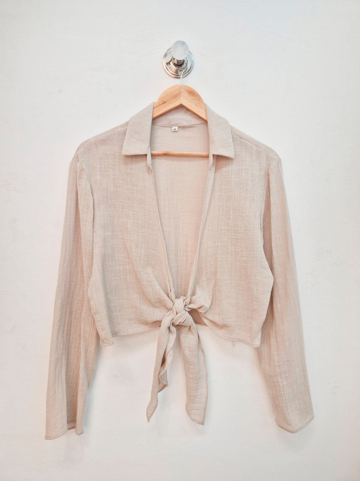 Blusa beige de lino con cuello solapa y nudo frontal
