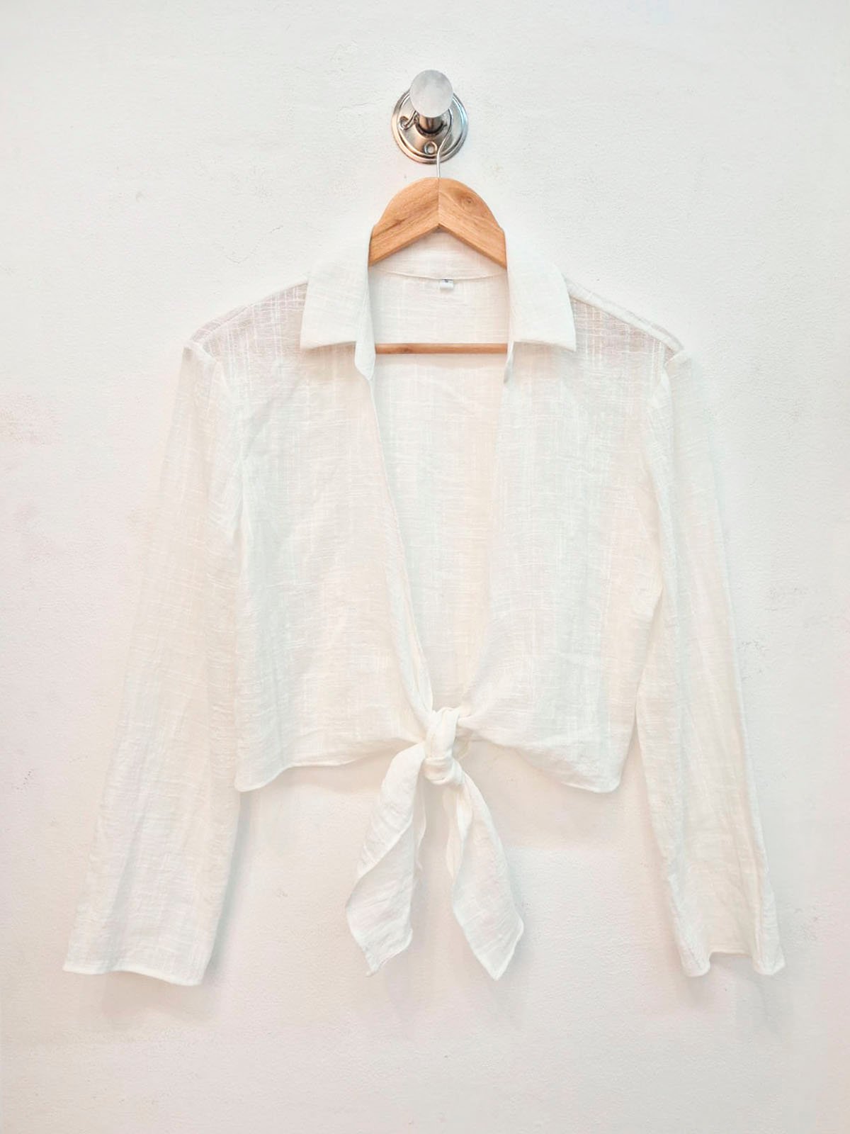 Blusa blanca de lino con escote abierto y nudo al frente