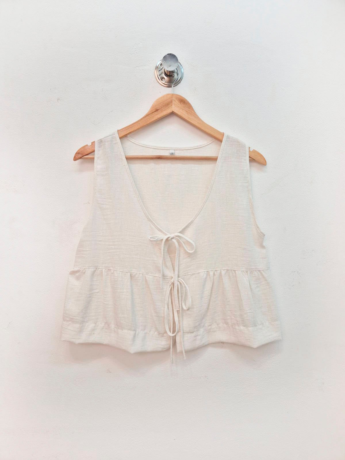 Blusa blanca sin mangas con escote en V y cordones frontales