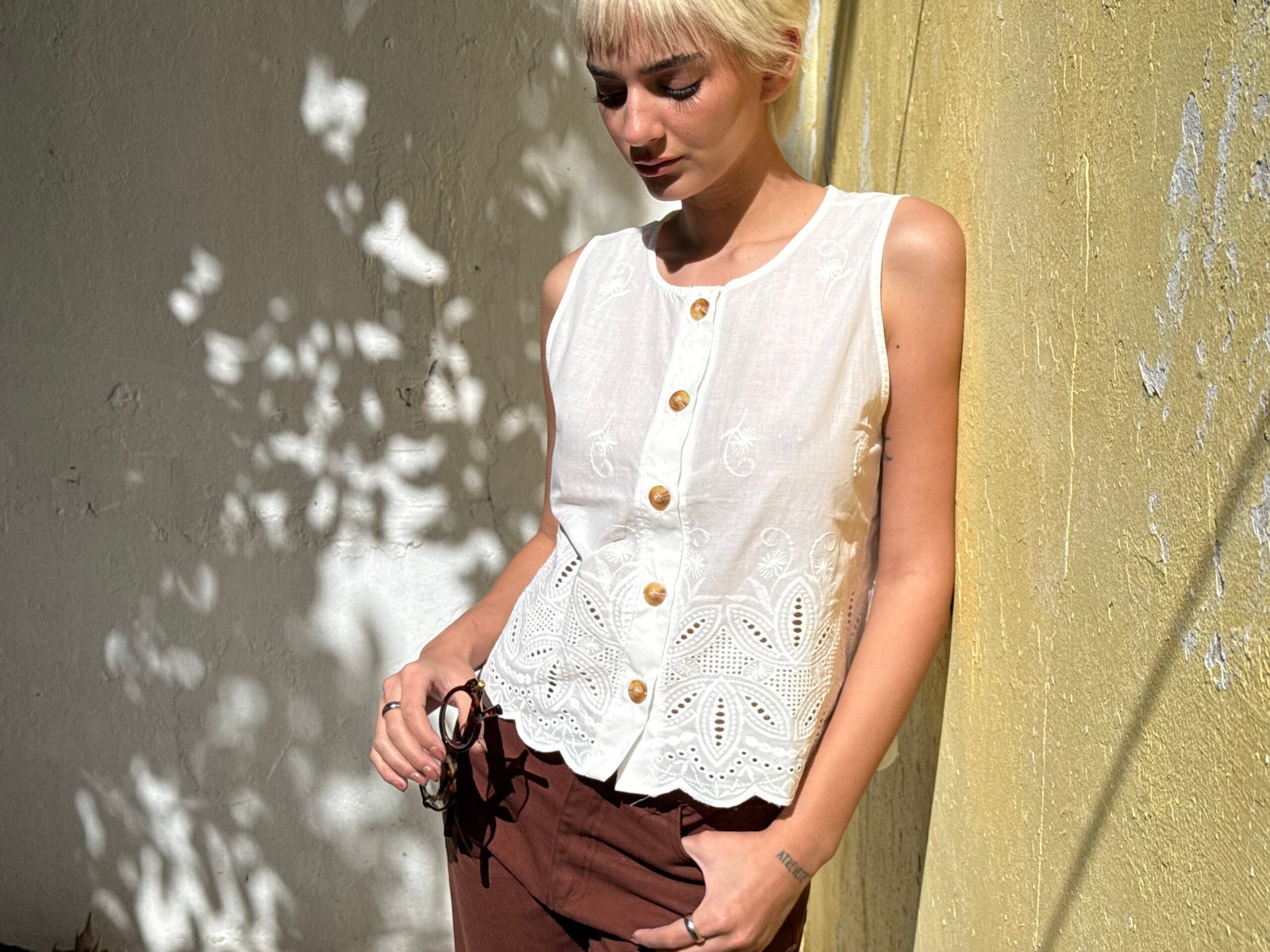 Blusa blanca sin mangas con botones y encaje calado en frente