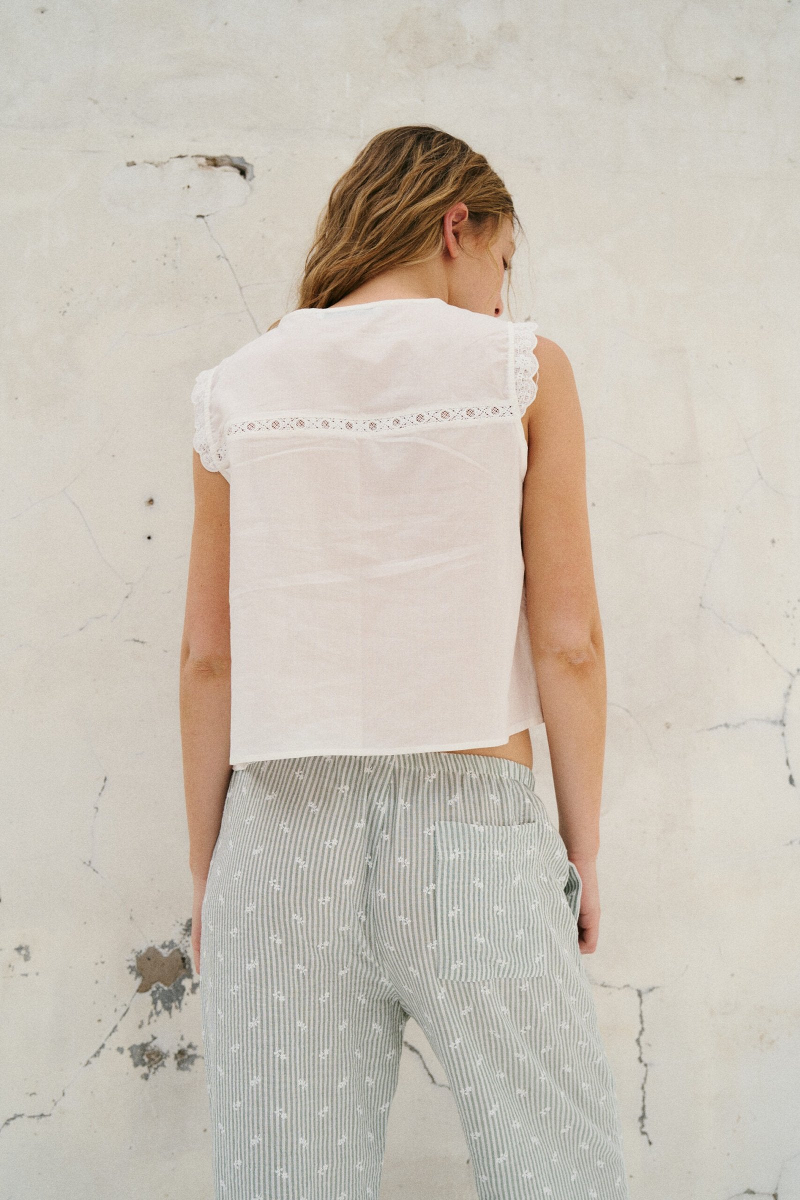 Blusa blanca sin mangas con encaje en escote y espalda