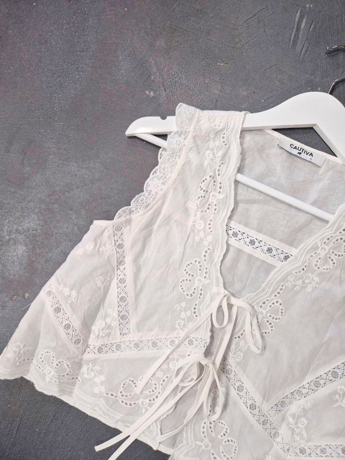Blusa blanca de lino con encaje calado y lazos laterales