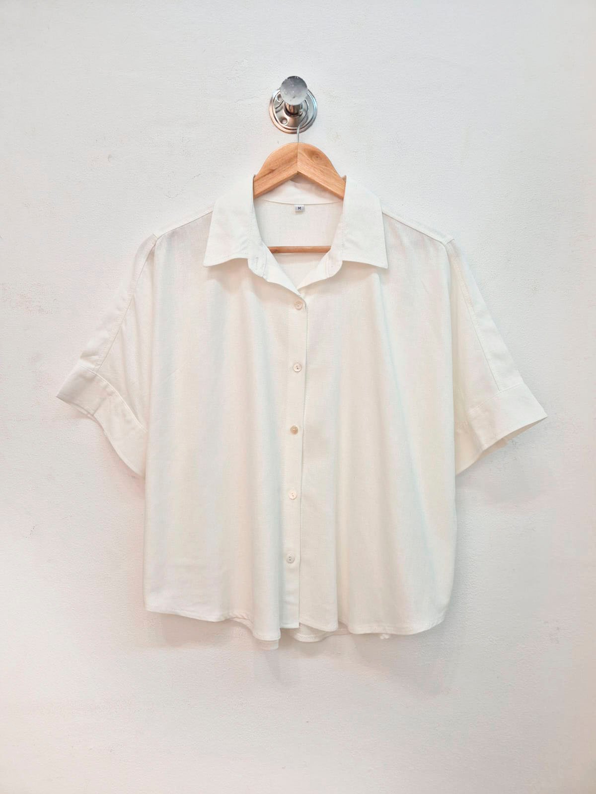 Camisa blanca de manga corta con cuello clásico y botones delanteros