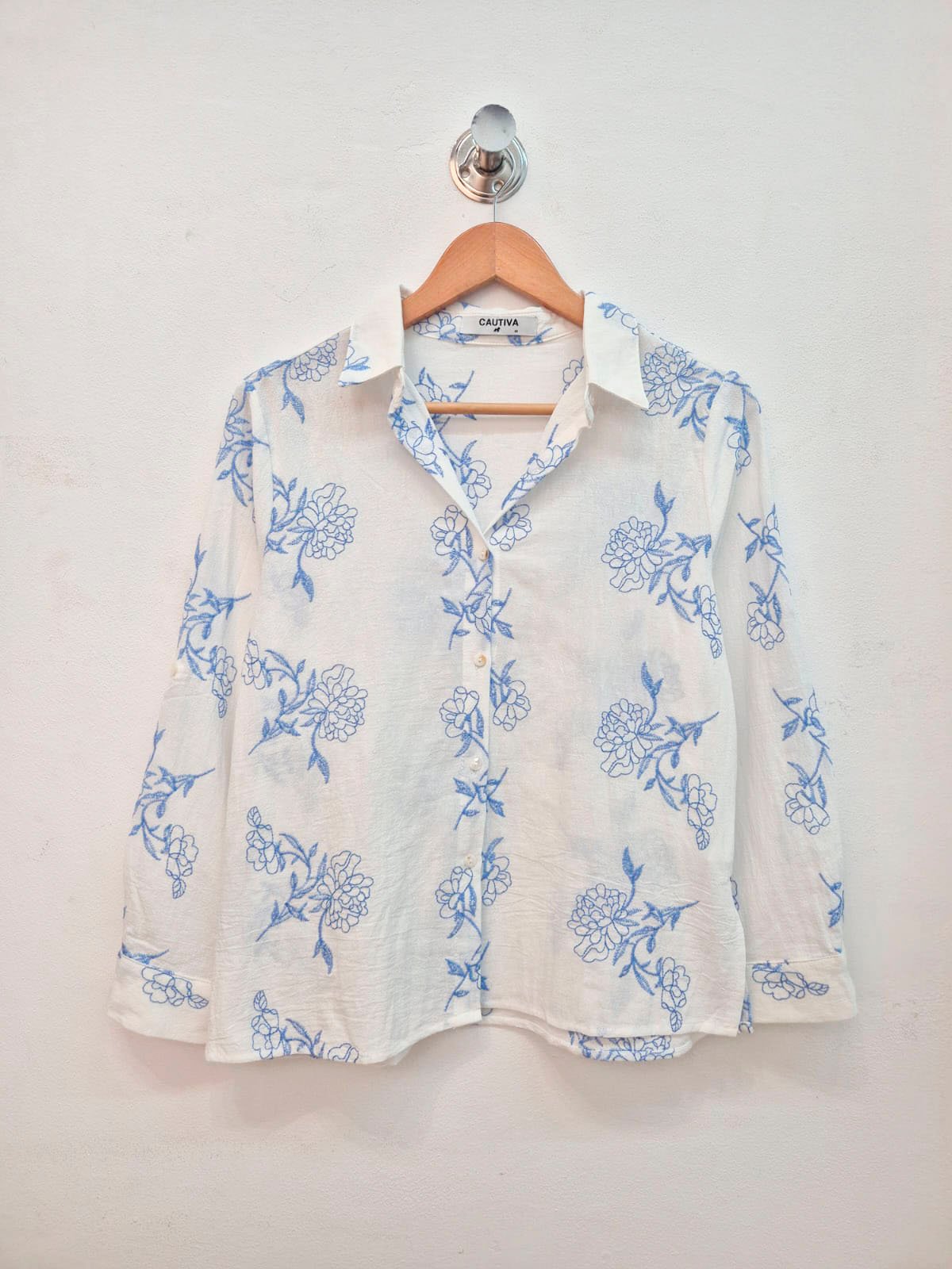 Camisa blanca con estampado floral azul y cuello solapa