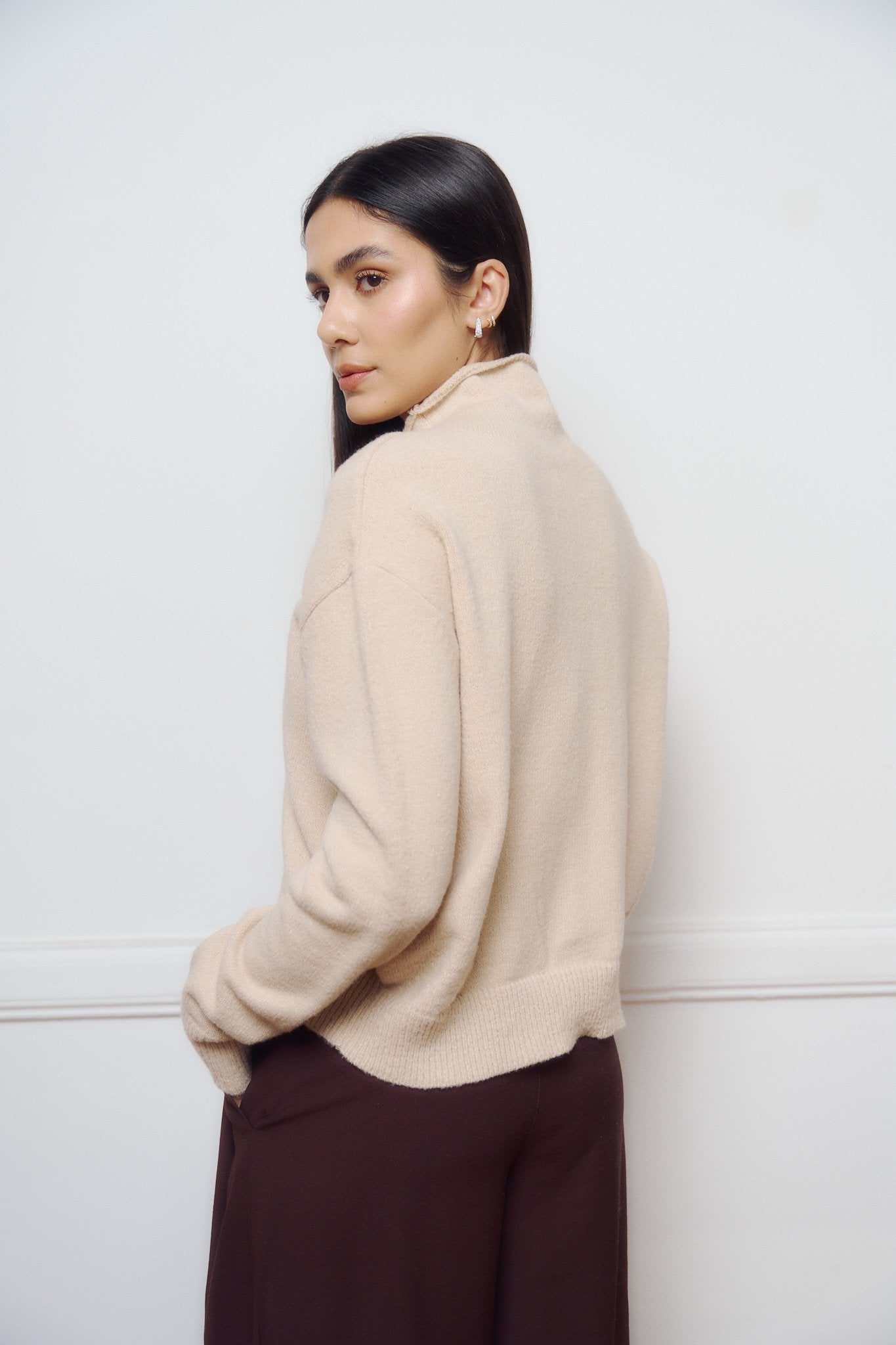 Saco beige de punto tejido con cuello alto y manga larga