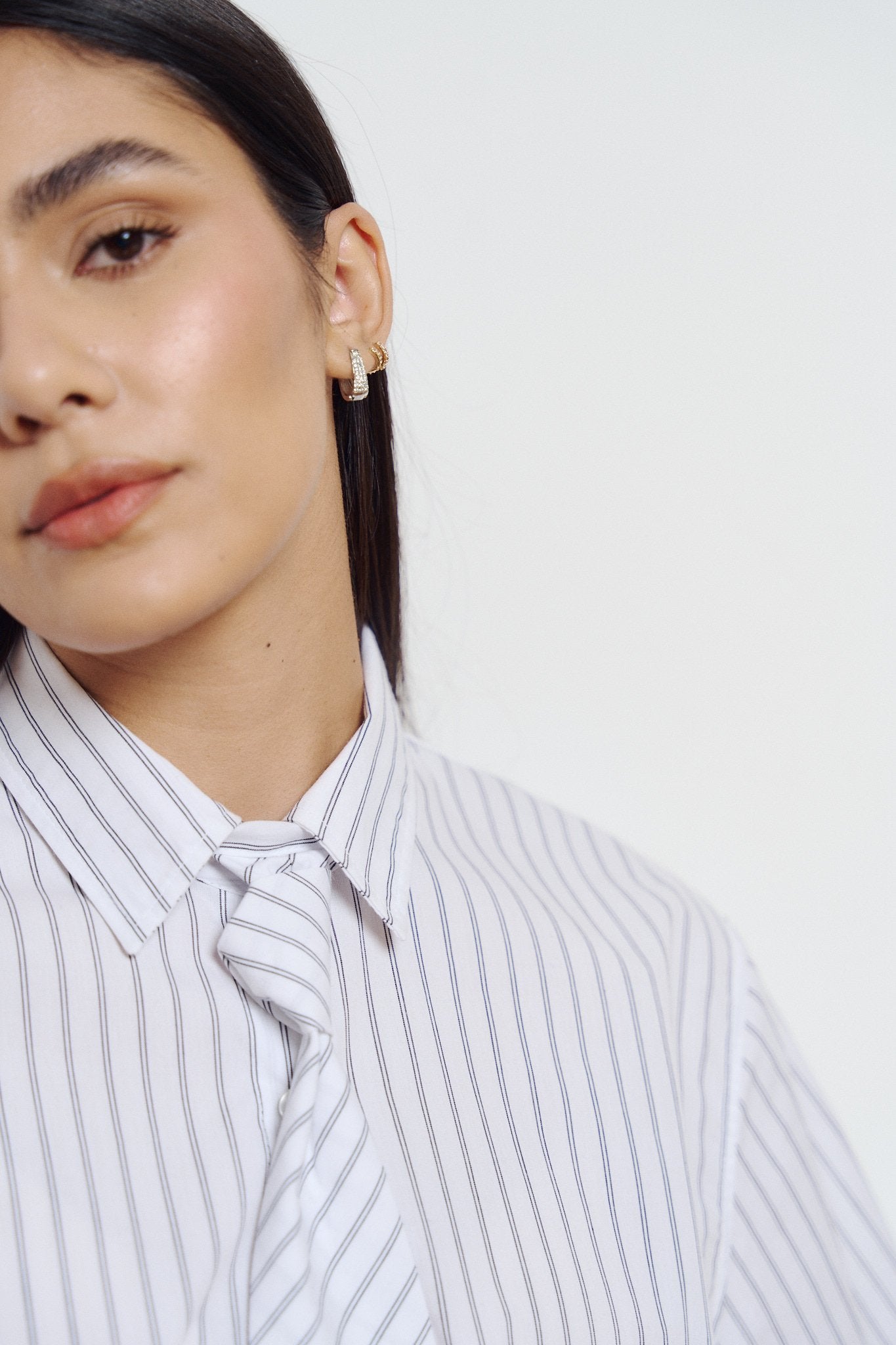 Camisa blanca con rayas verticales azul marino y frente fruncido