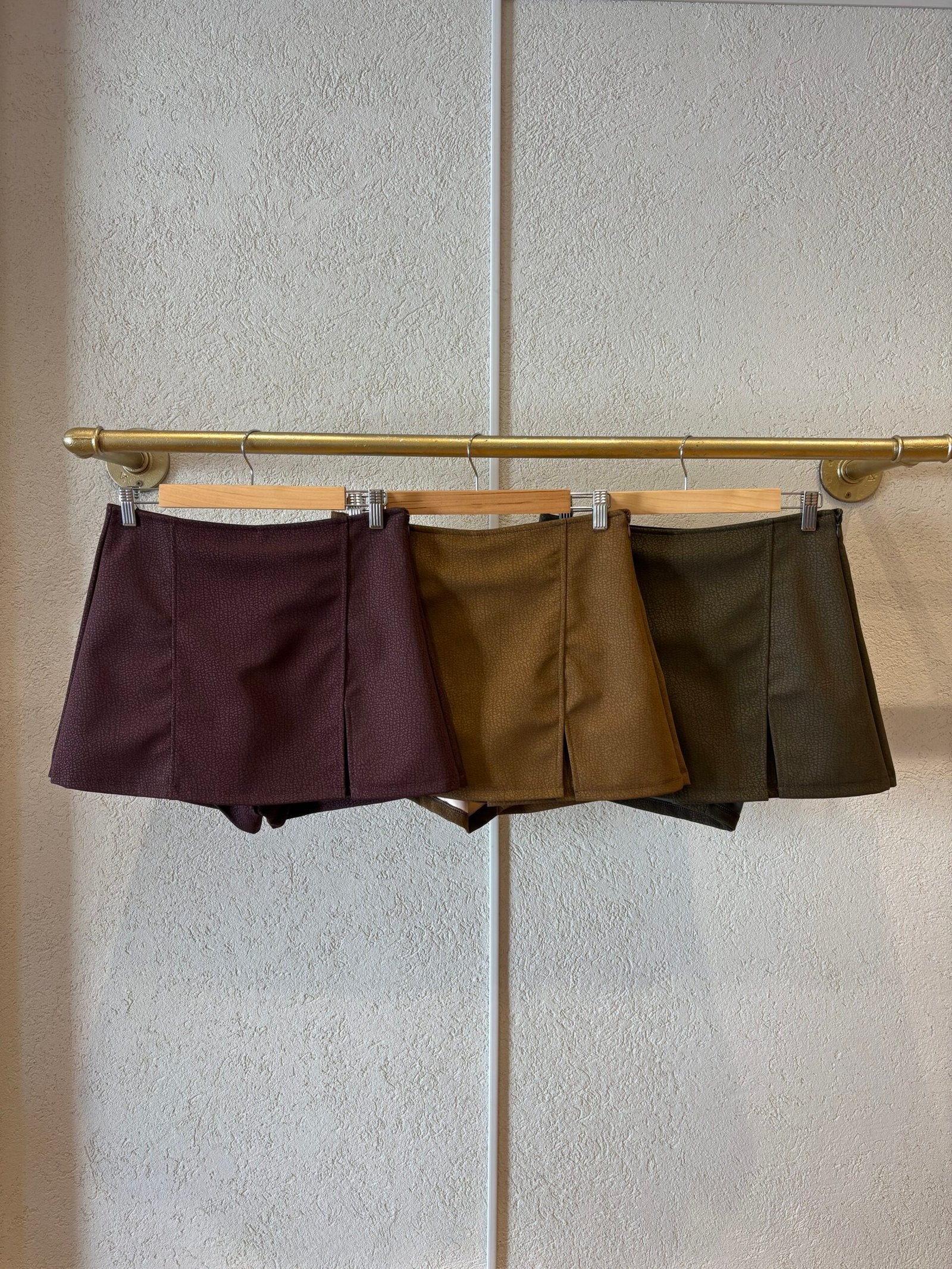 Skort en lana marrón oscuro con pliegues frontales y cierre lateral