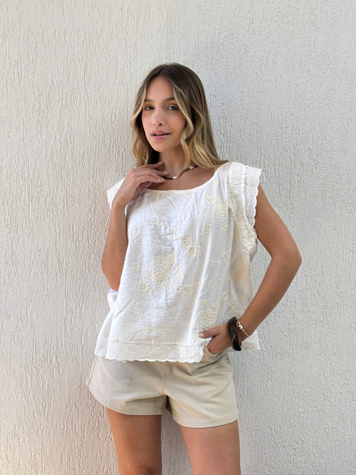 Blusa blanca de algodón con bordado floral y encaje en mangas
