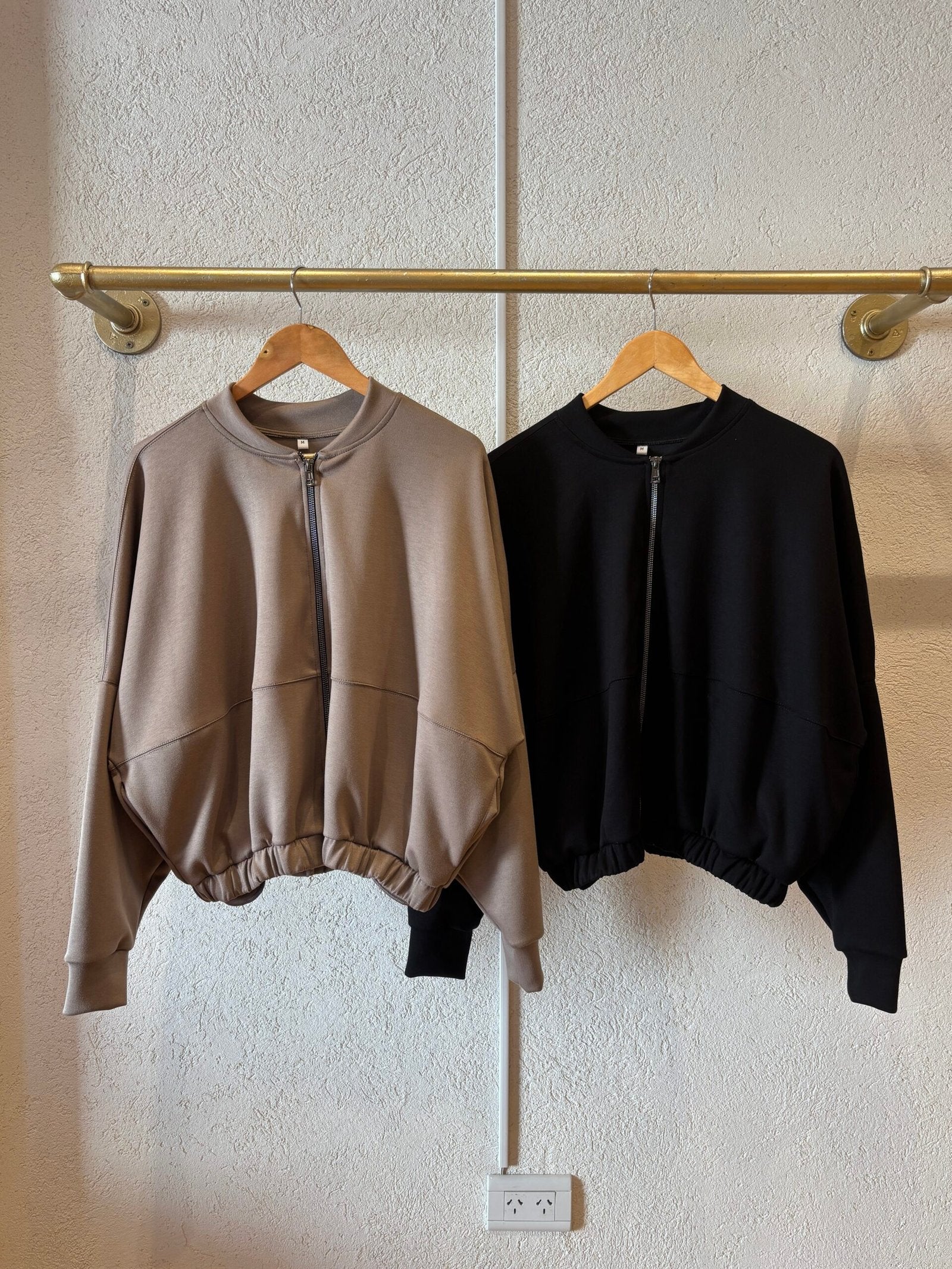 Campera corta beige con cierre frontal y puño acanalado