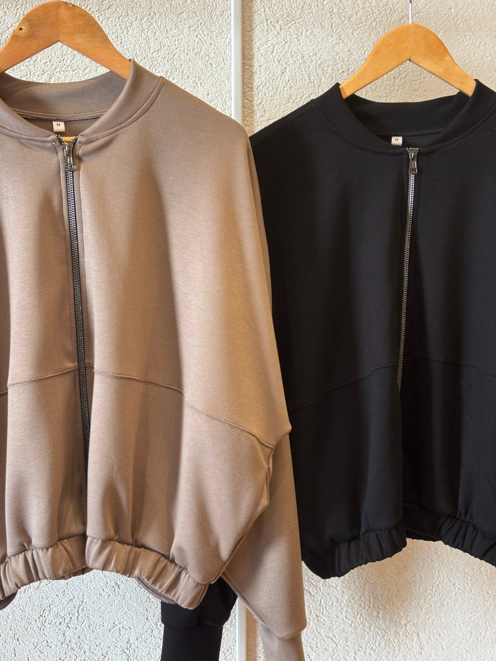 Campera beige y negra con cierre frontal y puños elásticos