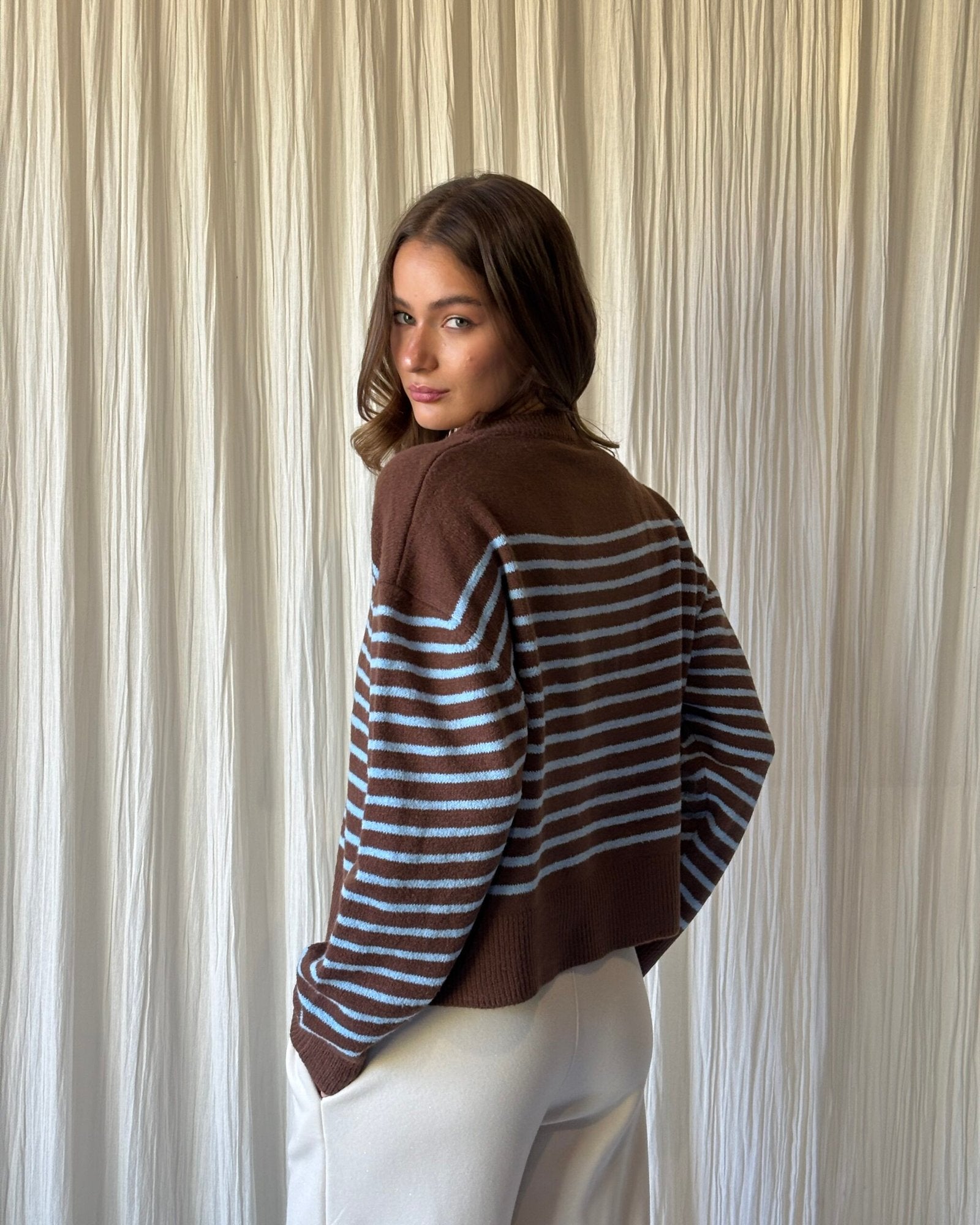 Sweater marrón con rayas azules y blancas en mangas