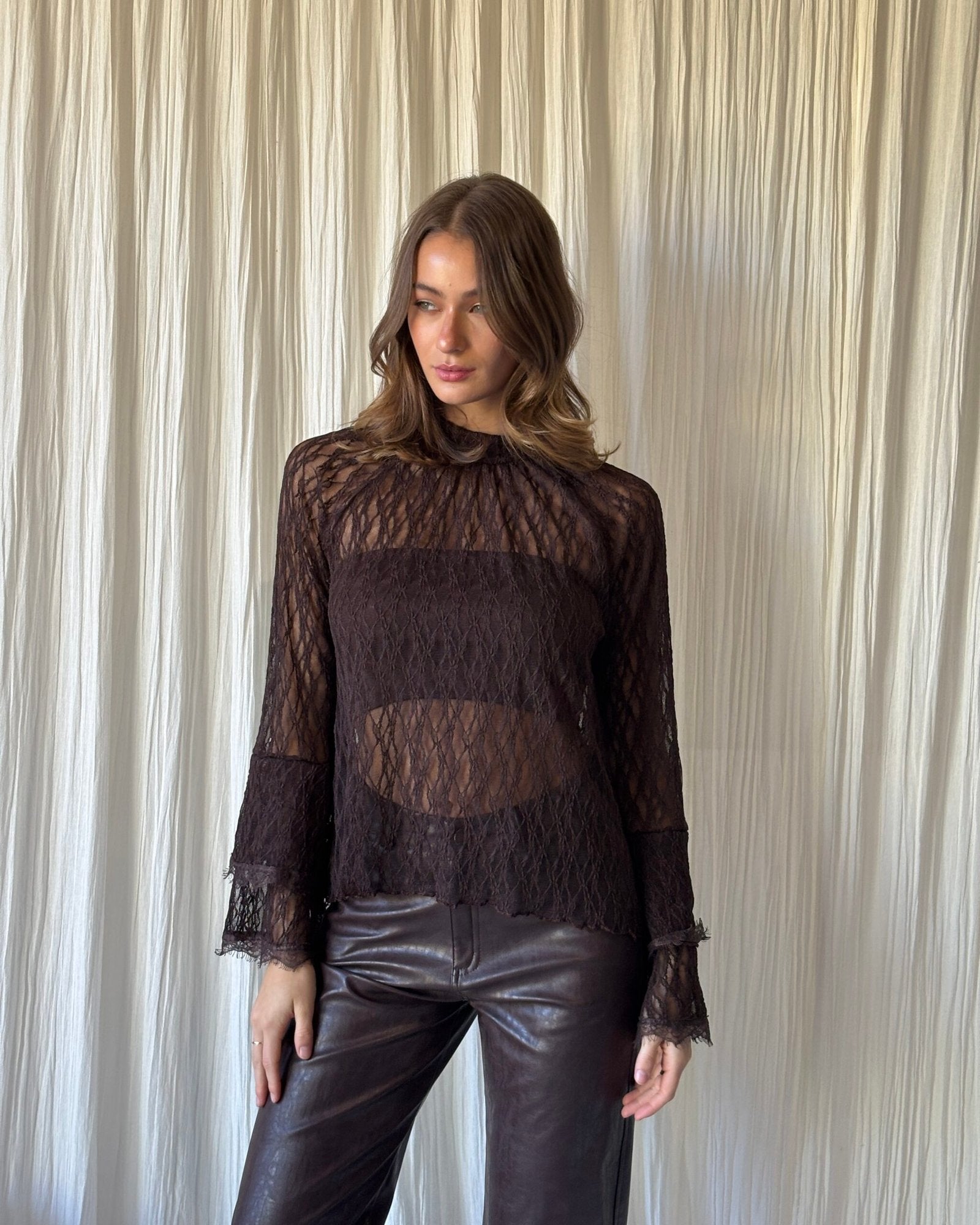 Blusa de encaje negro con manga larga y puños fruncidos