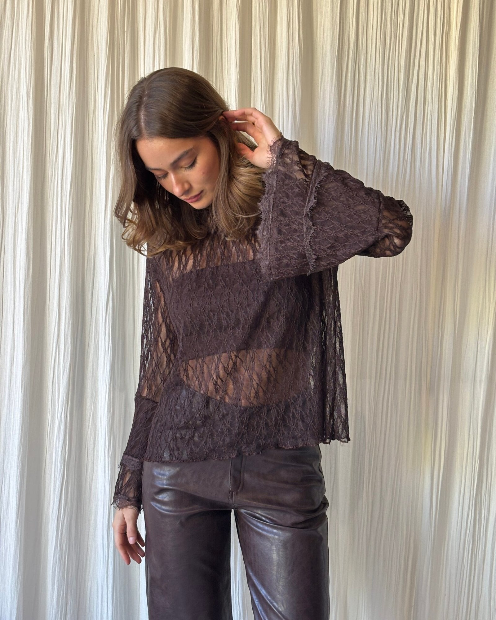 Blusa de encaje negro con manga larga y escote redondo