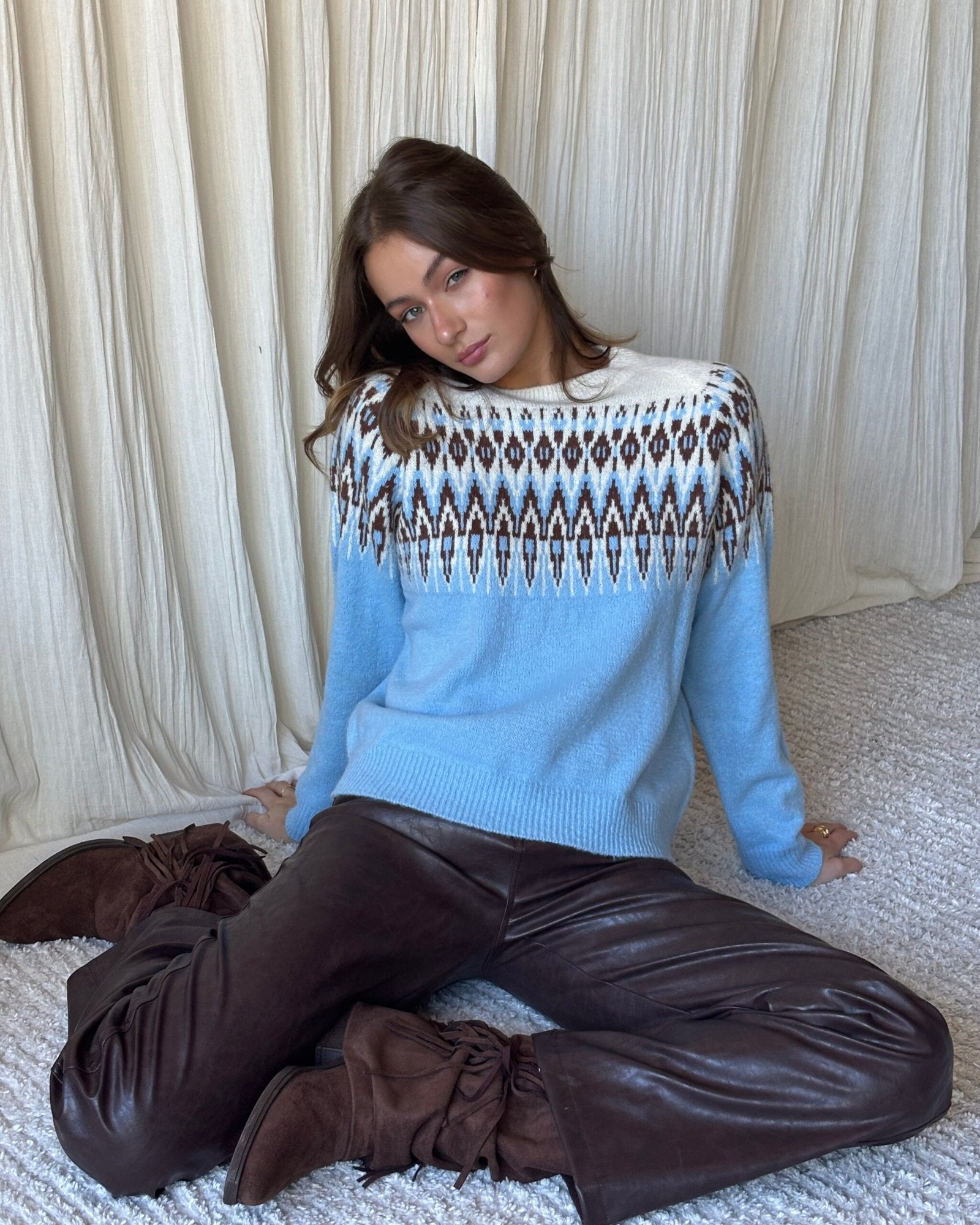Sweater azul cielo con patrón geométrico blanco y marrón en el pecho