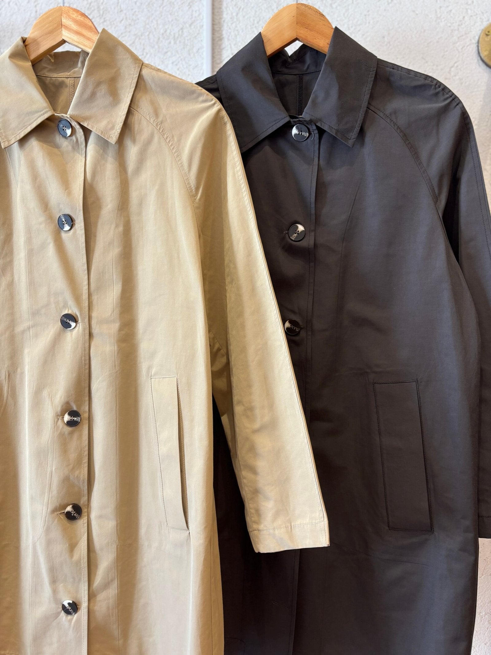 Trench beige con solapa, botones y bolsillos delanteros