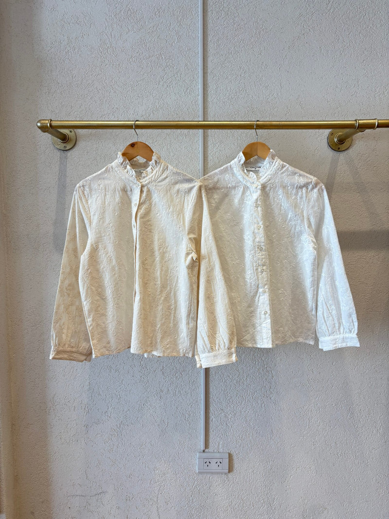 Camisa blanca de algodón con textura bordada y cuello alto