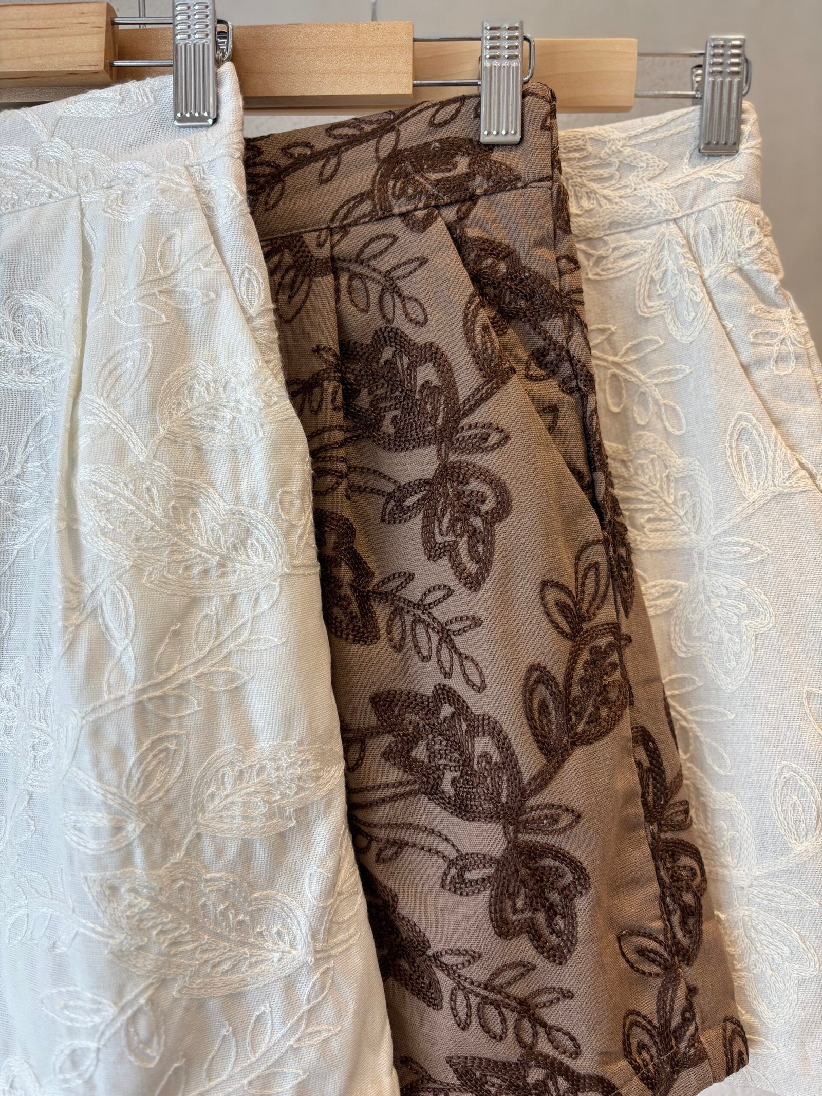 Falda corta beige con estampado de hojas marrones tejido