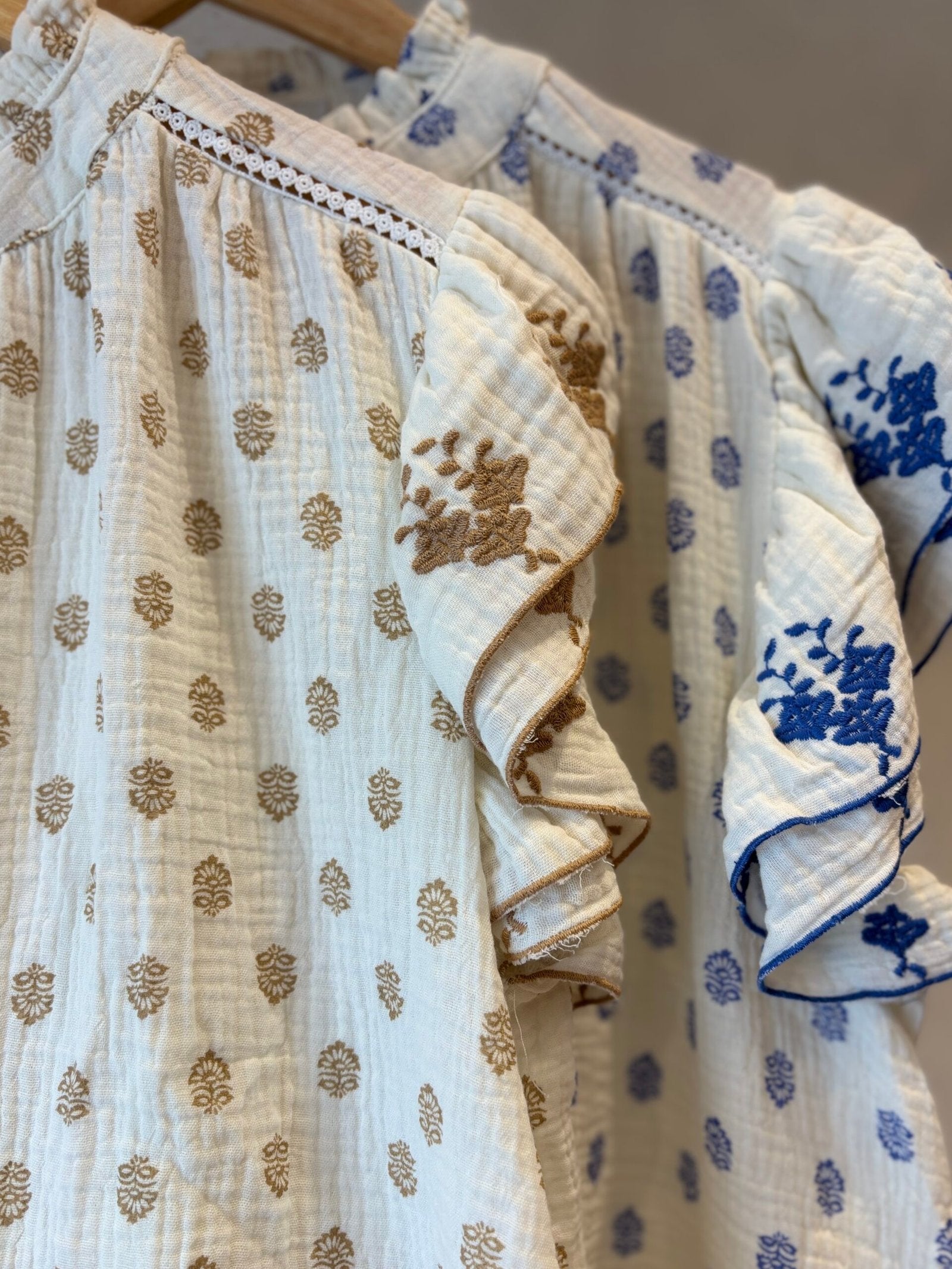 Camisa blanca de algodón con estampado de flores camel y volado en manga