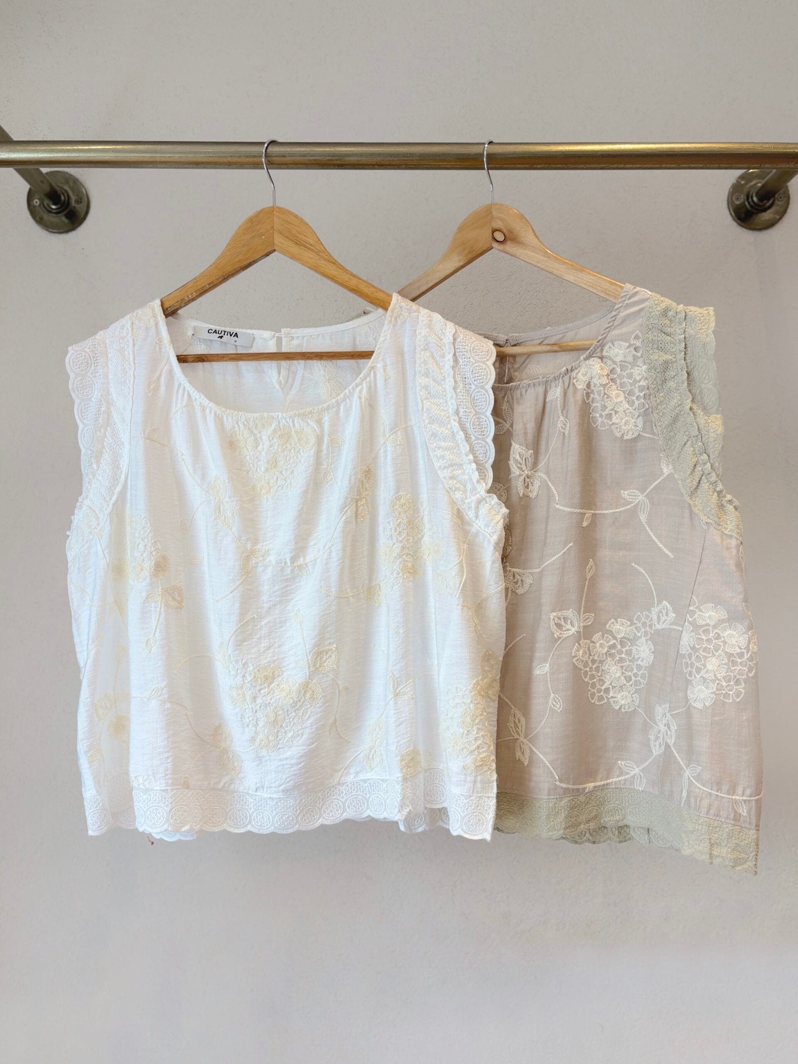 Blusa sin manga blanca con encaje floral y borde ondulado