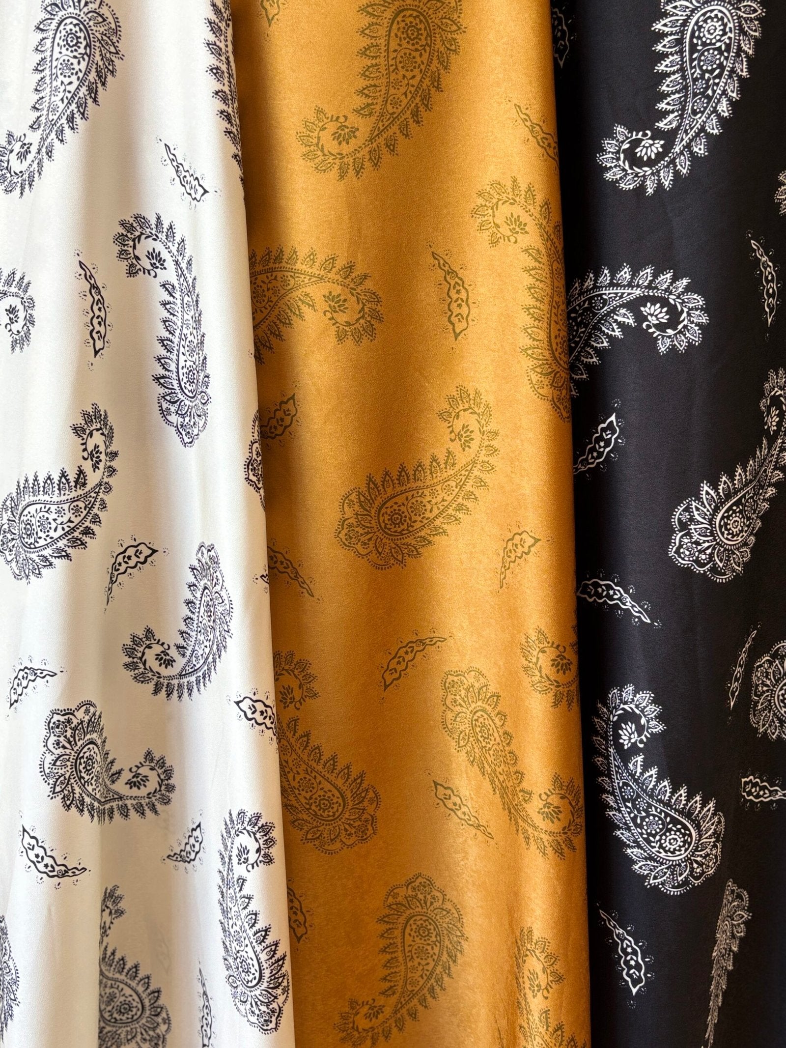 Tela estampada con motivo paisley en blanco, dorado y negro