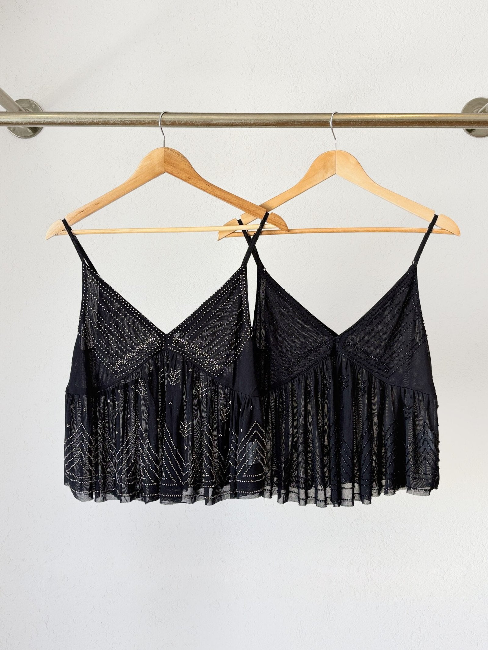 Musculosa negra de encaje con escote V y volados en bajo