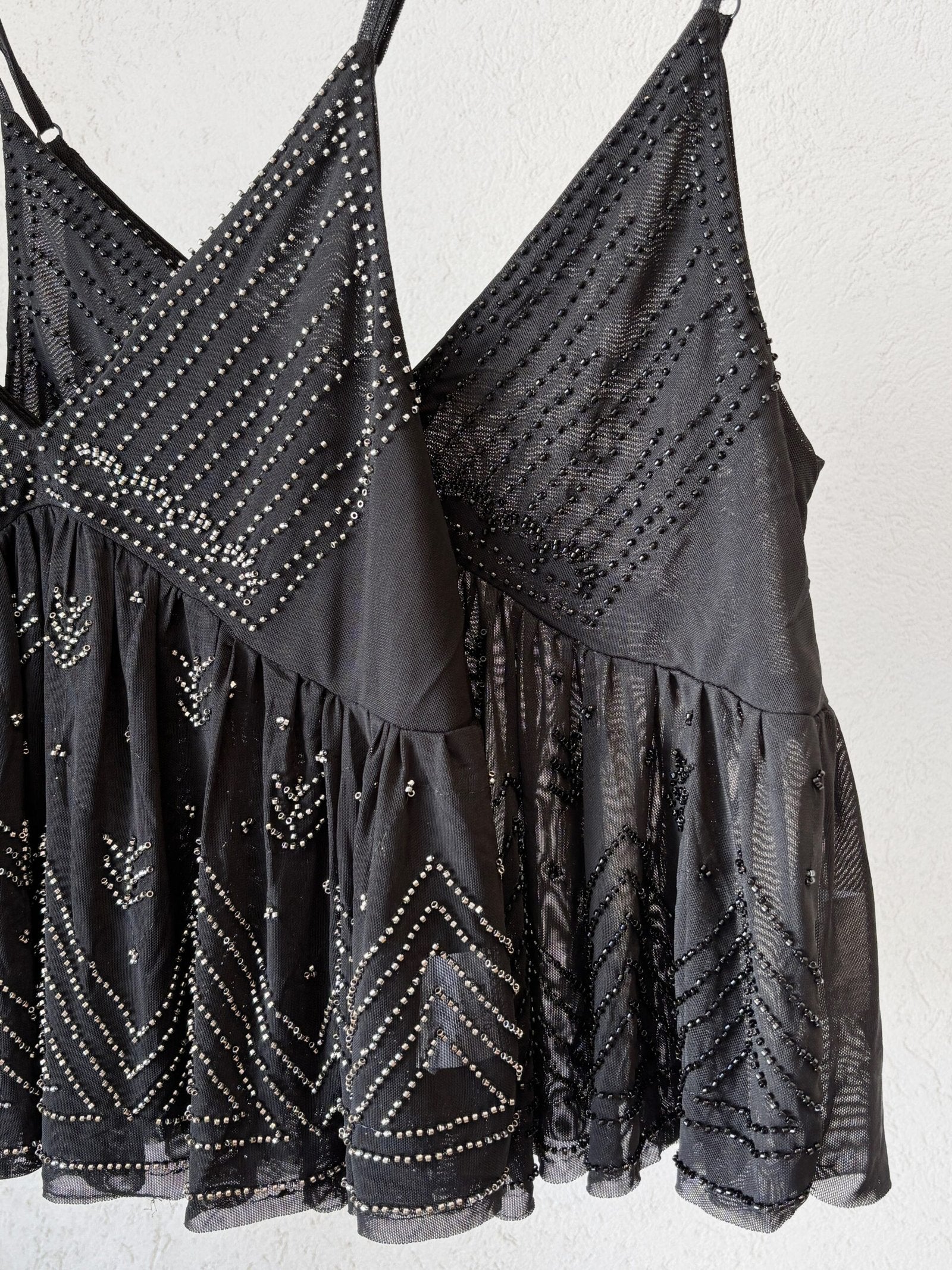 Musculosa negra con escote en V y aplicaciones brillantes geométricas