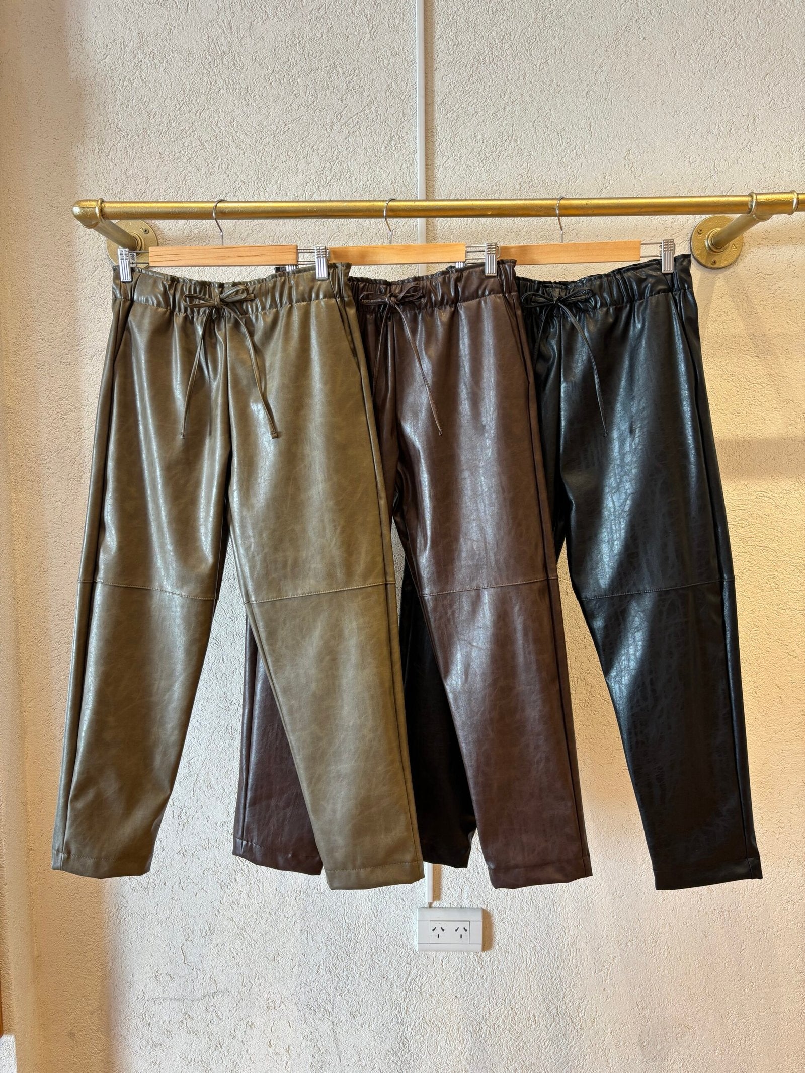 Pantalón de cuero sintético negro con cintura elástica y largo tobillero
