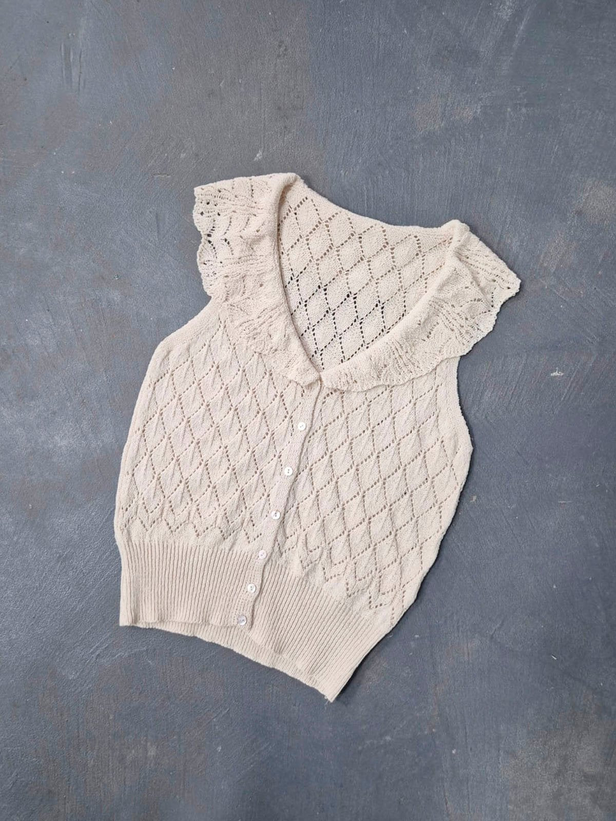 Musculosa beige calada con cuello volado y botones frontales