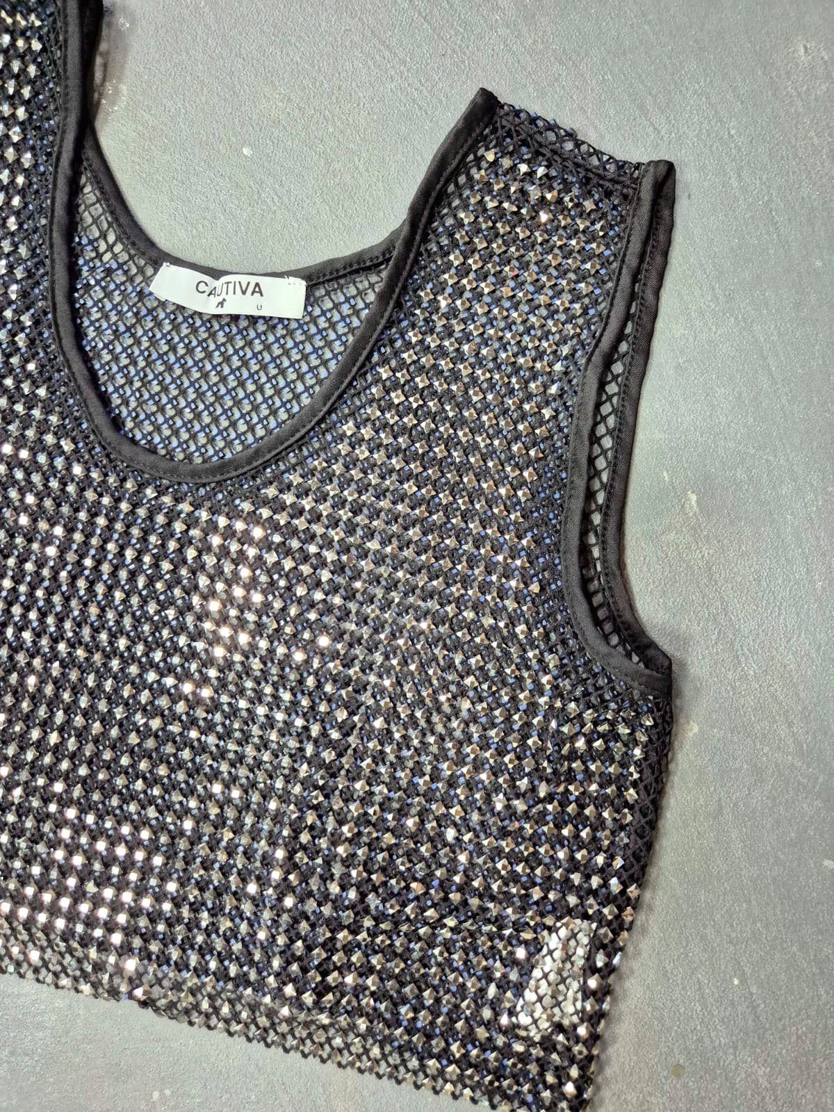 Musculosa negra con lentejuelas plateadas y ribete negro