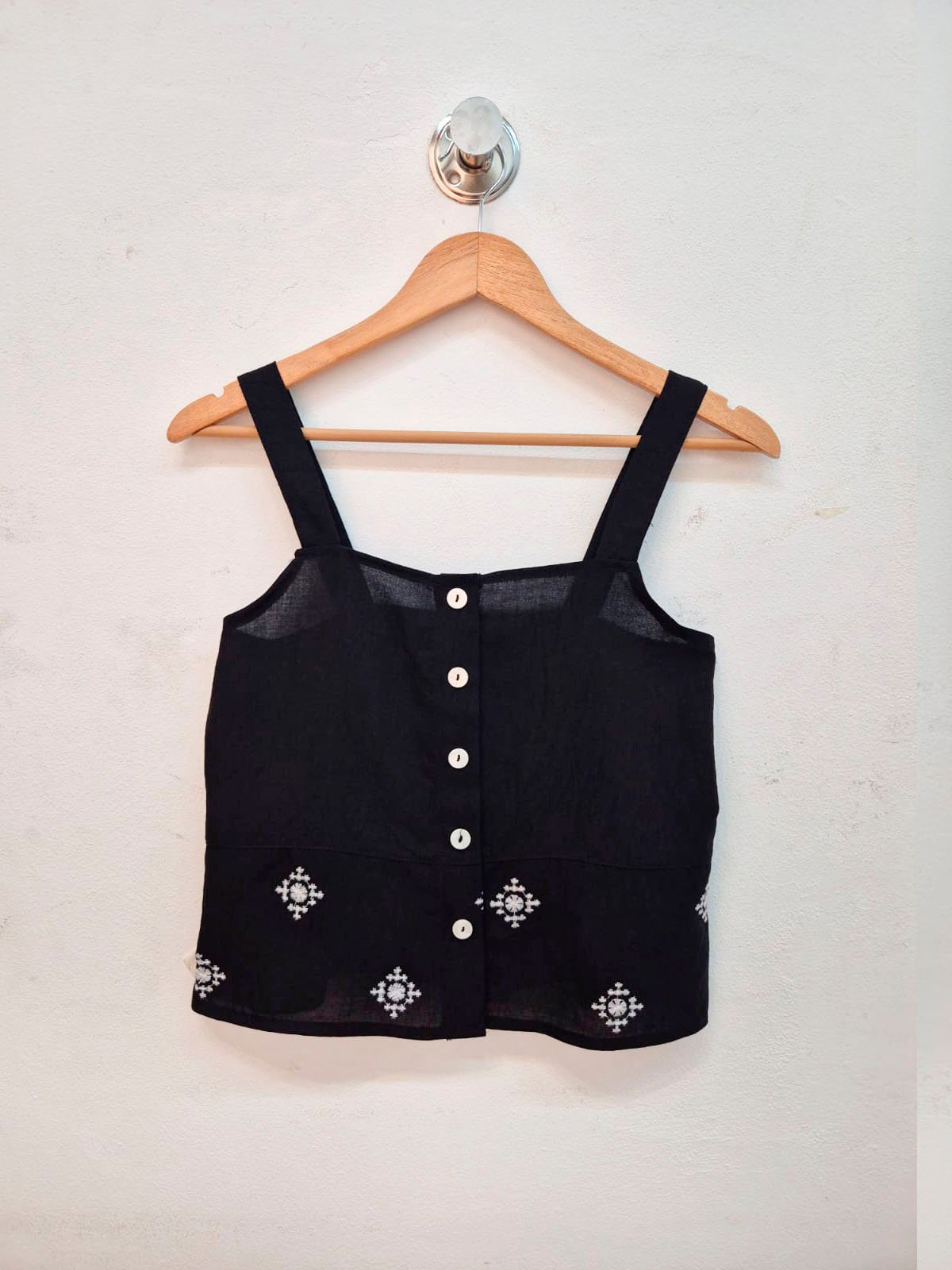 Top negro de lino con botones blancos y bordados florales