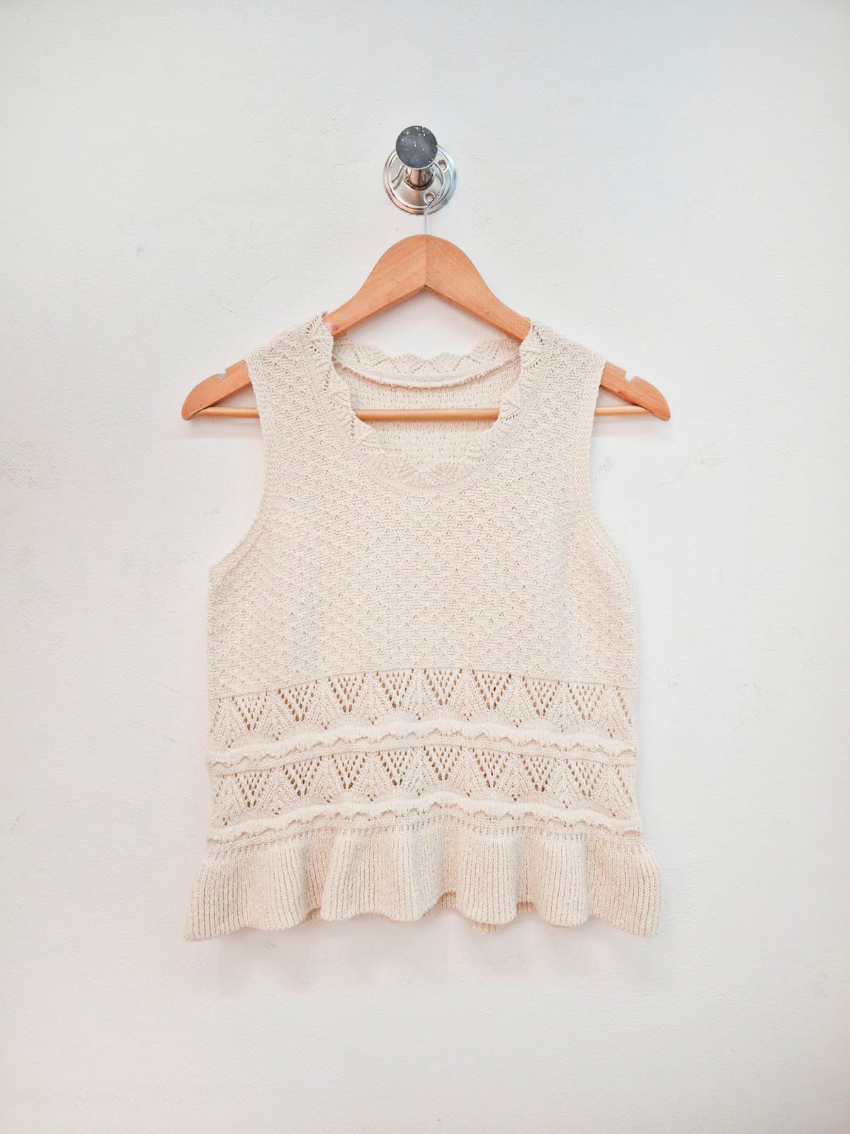 Musculosa beige de punto con detalles calados y volante en ruedo