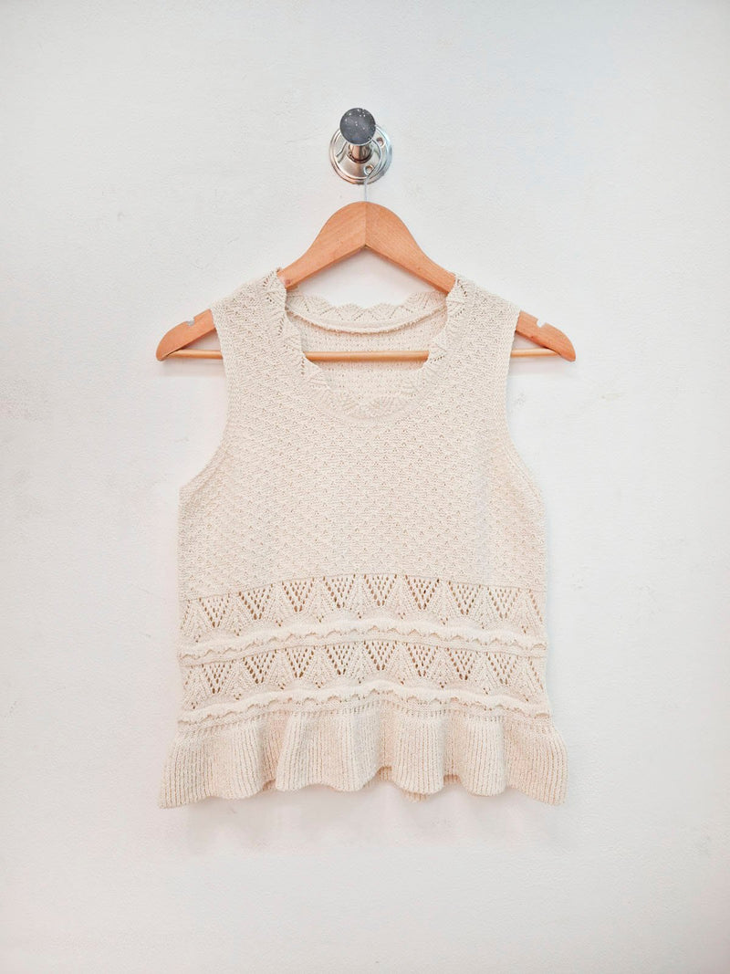 Musculosa beige de punto con detalles calados y volante en ruedo