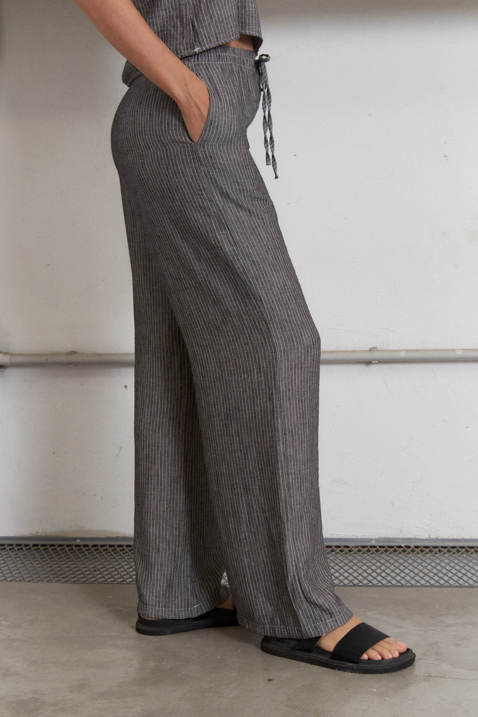 Pantalón gris a rayas verticales con cintura ajustable y bolsillos