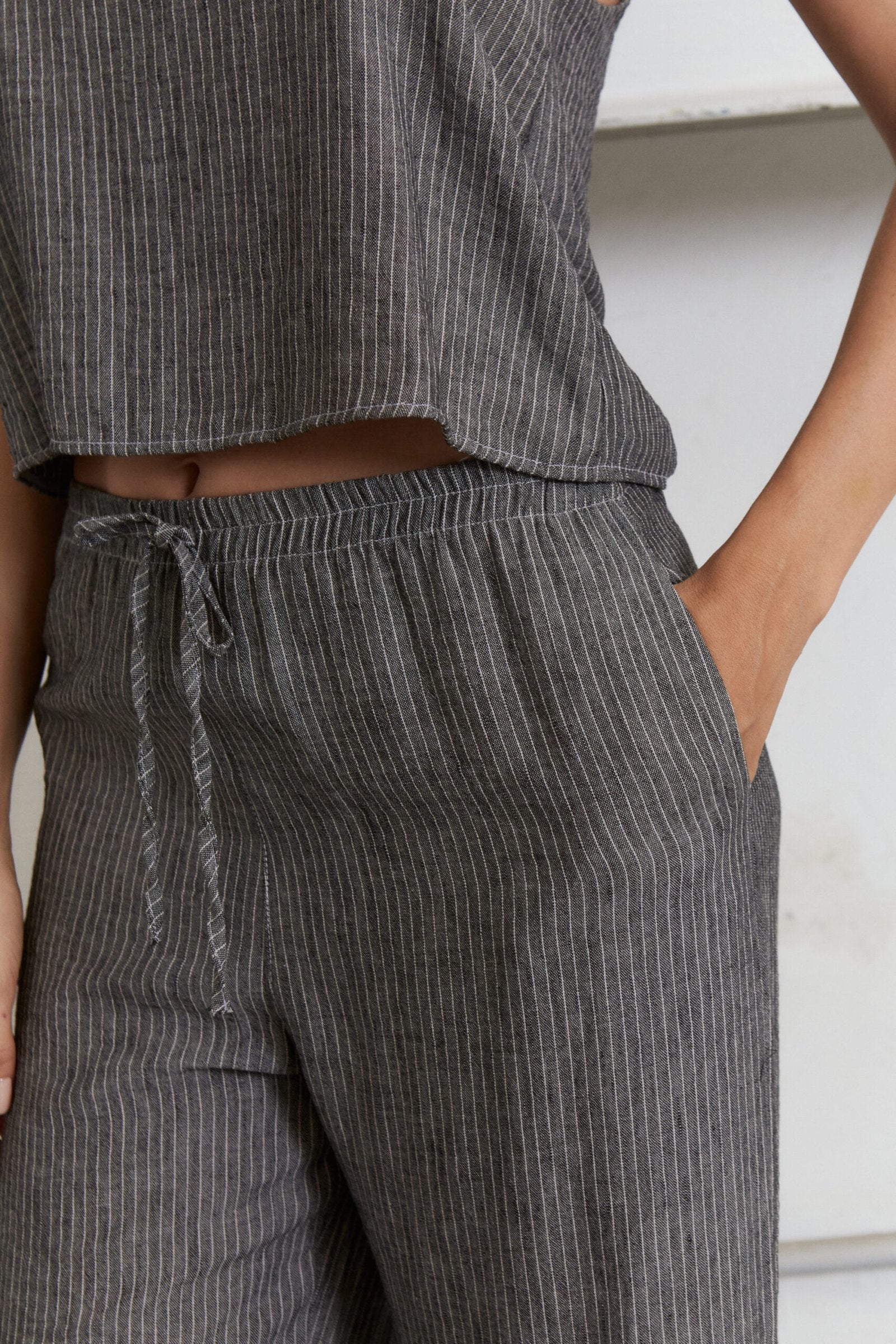 Pantalón gris con rayas verticales blancas y cintura ajustable