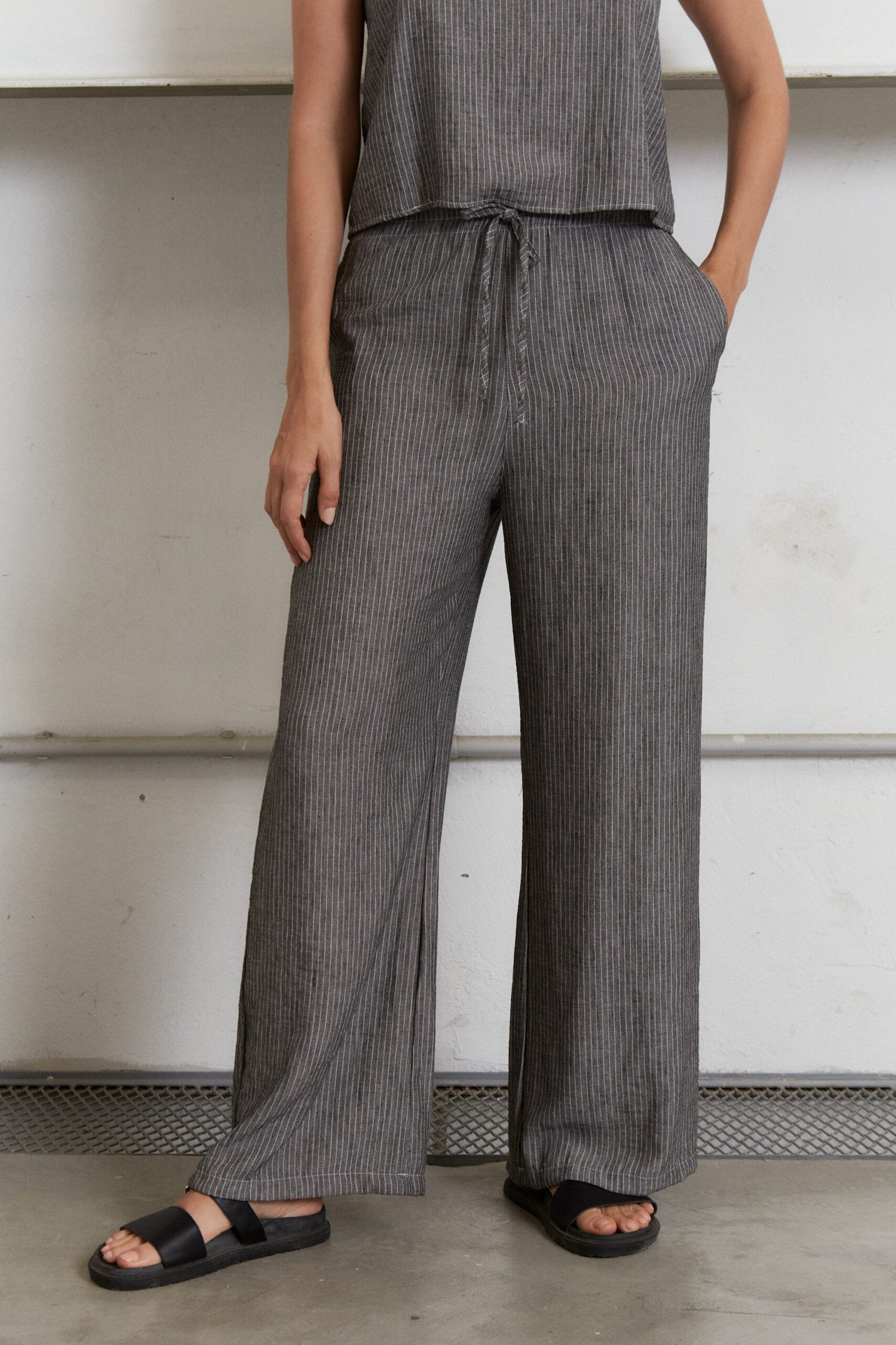 Pantalón gris con rayas verticales, tiro alto y pierna ancha