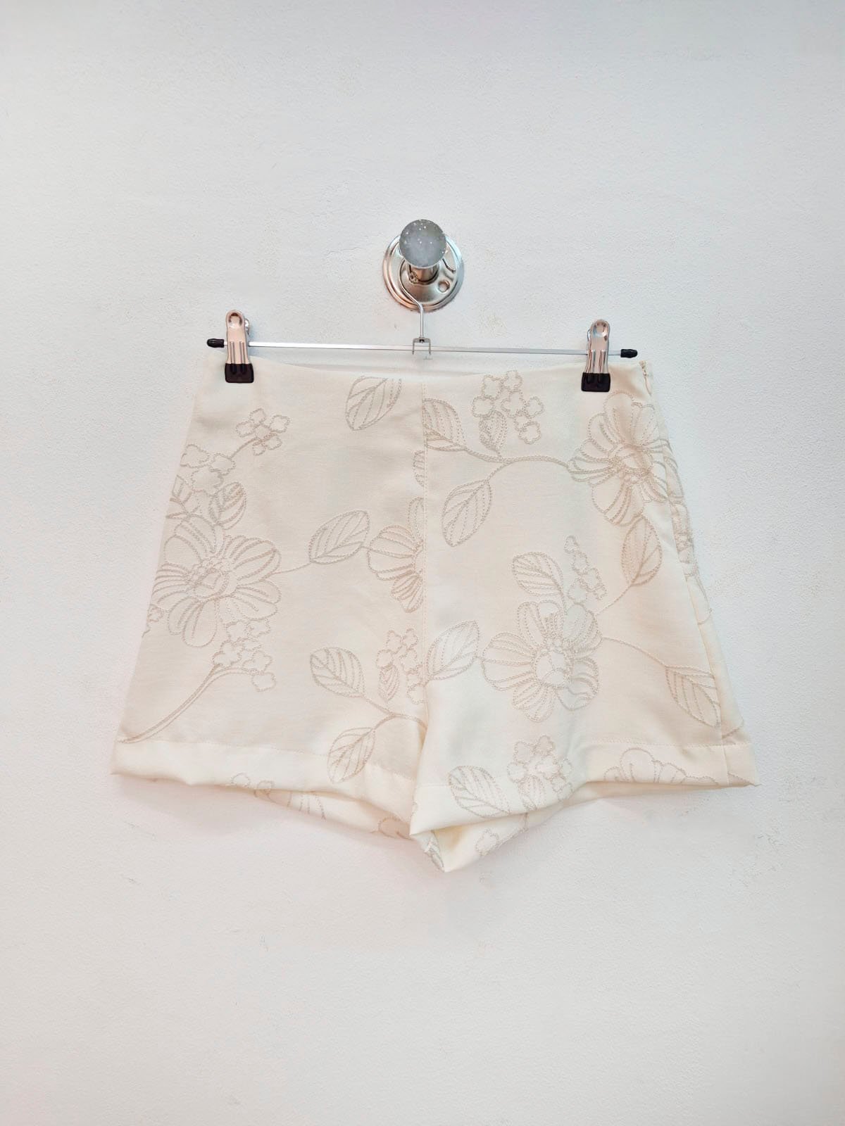 Short beige con estampado floral bordado en tonos neutros