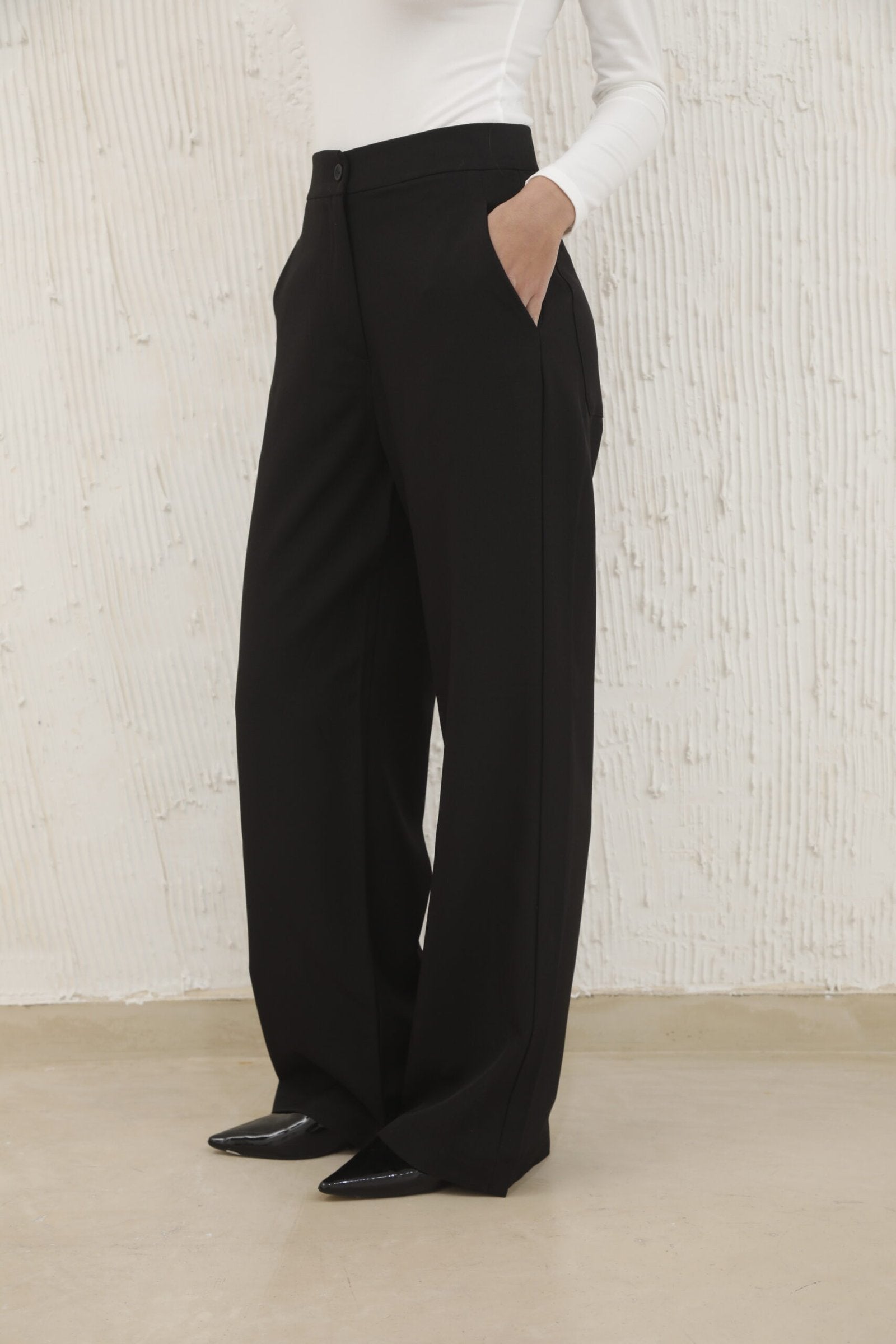 Pantalón negro de tiro alto con pierna ancha y bolsillos laterales