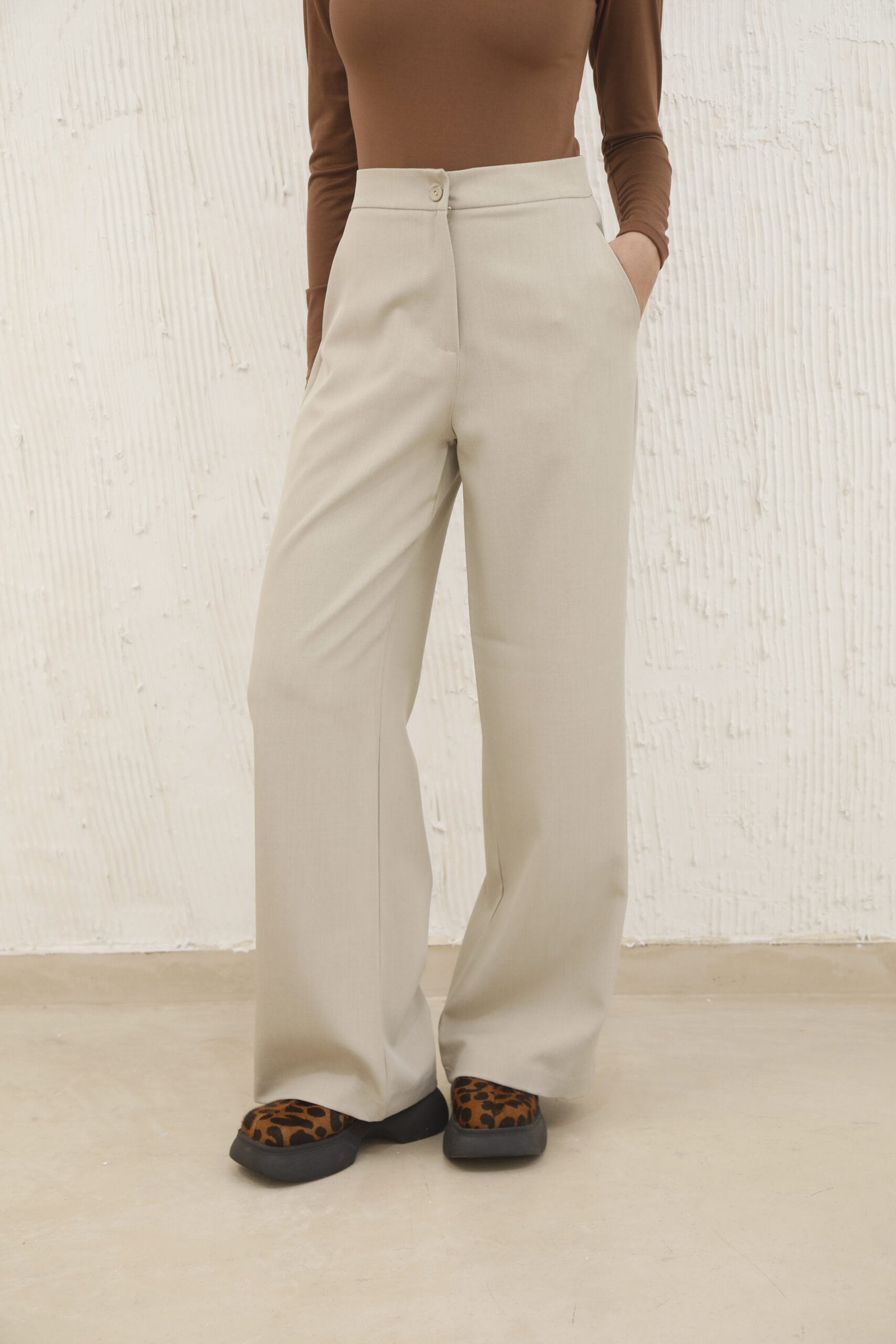 Pantalón beige de tiro alto y pierna recta con bolsillos