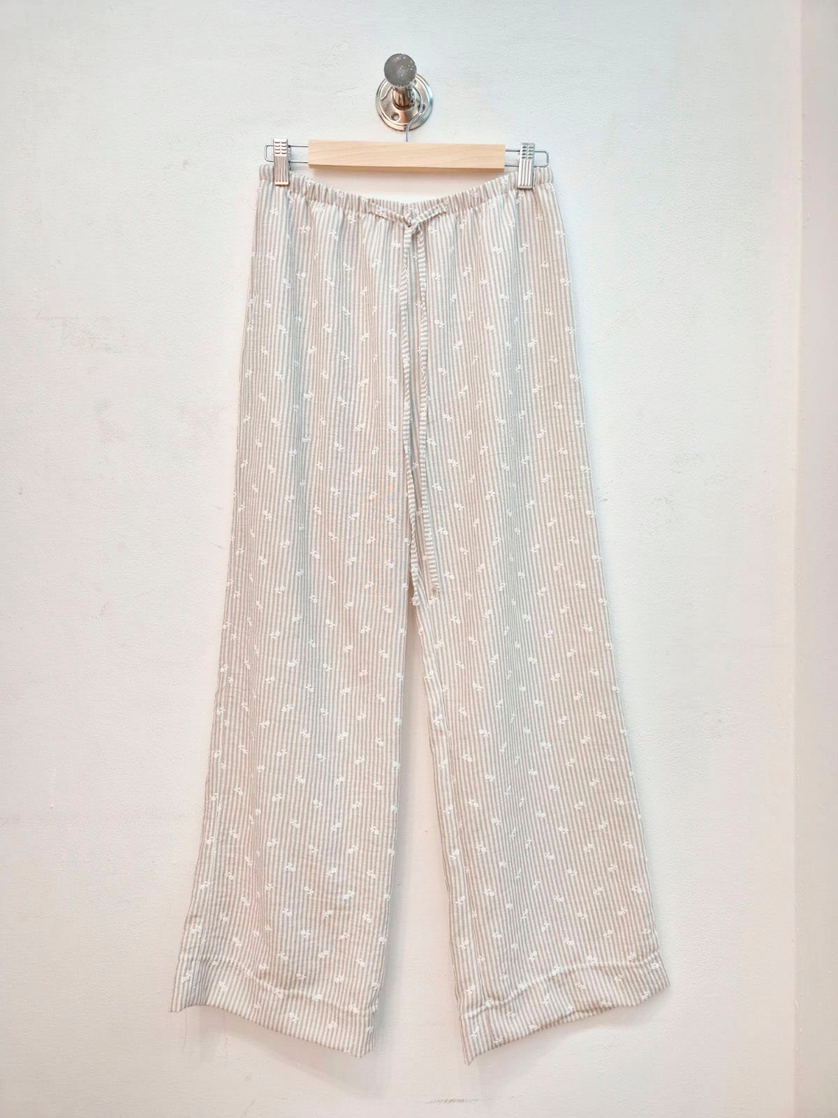 Pantalón de tiro alto acanalado beige con estampado floral blanco