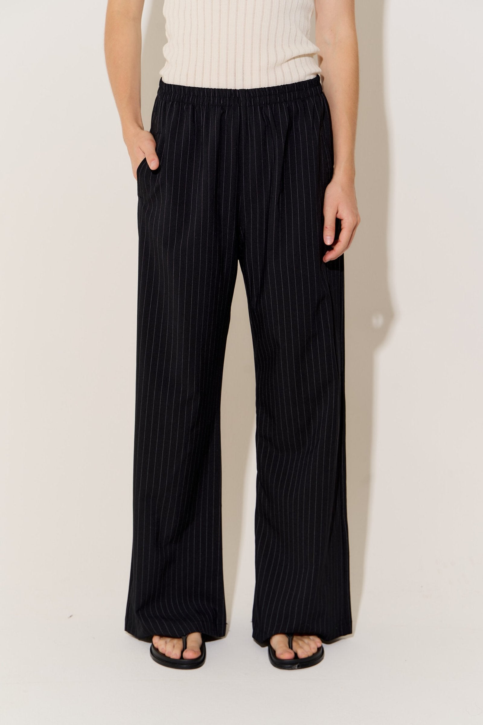 Pantalón negro de rayas blancas con tiro alto y pierna recta