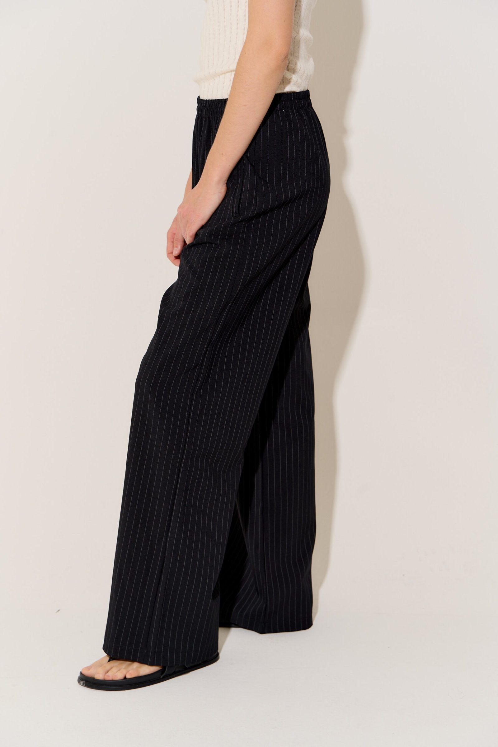 Pantalón negro a rayas verticales blancas de tiro alto