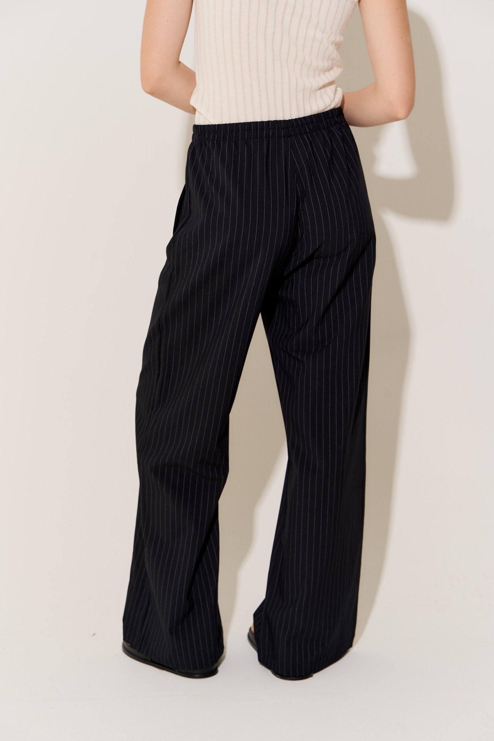 Pantalón negro de tiro alto con rayas verticales y pierna ancha